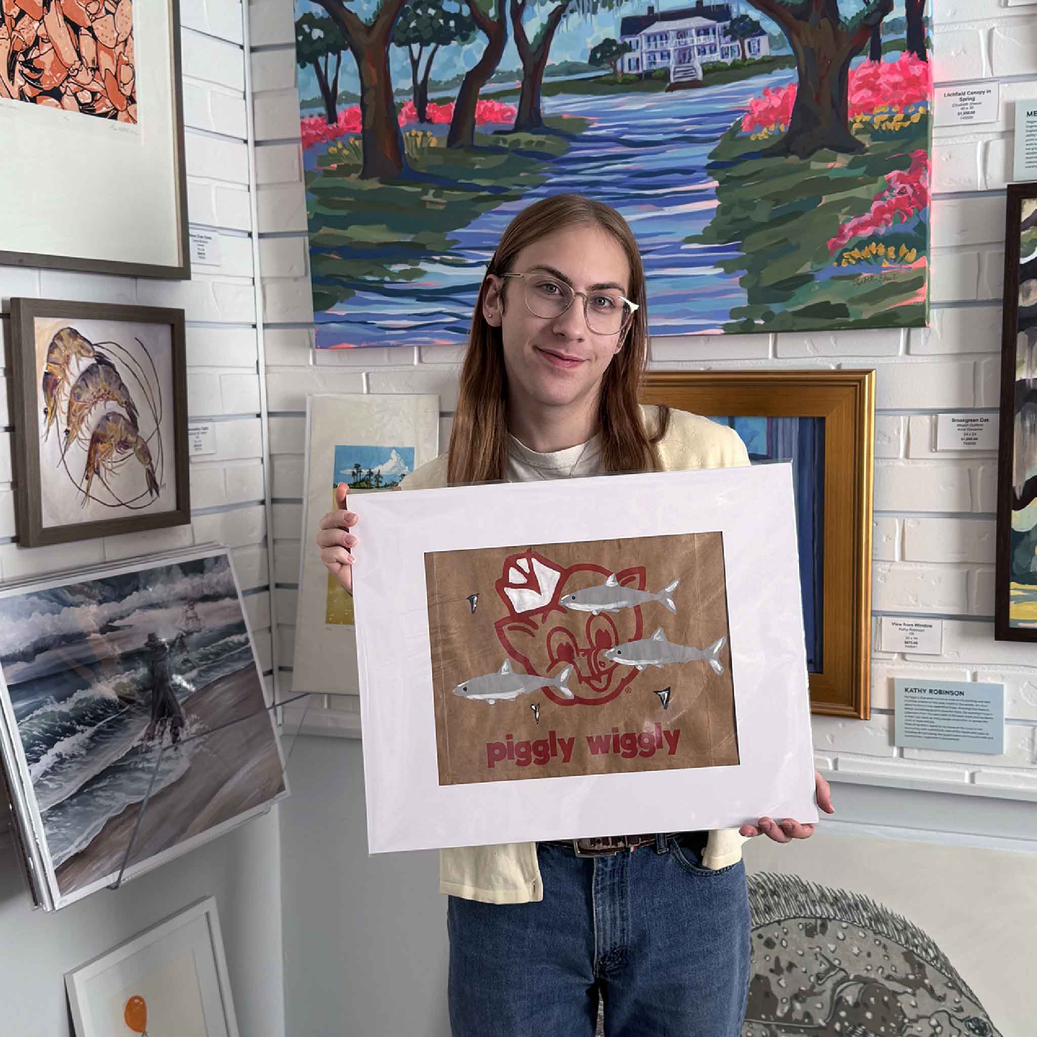 Jenny Reynolds’ Piggly Wiggly Sharks artwork painted on a grocery bag, featuring the classic logo with swimming sharks, shown matted for scale inside Gray Man Gallery.