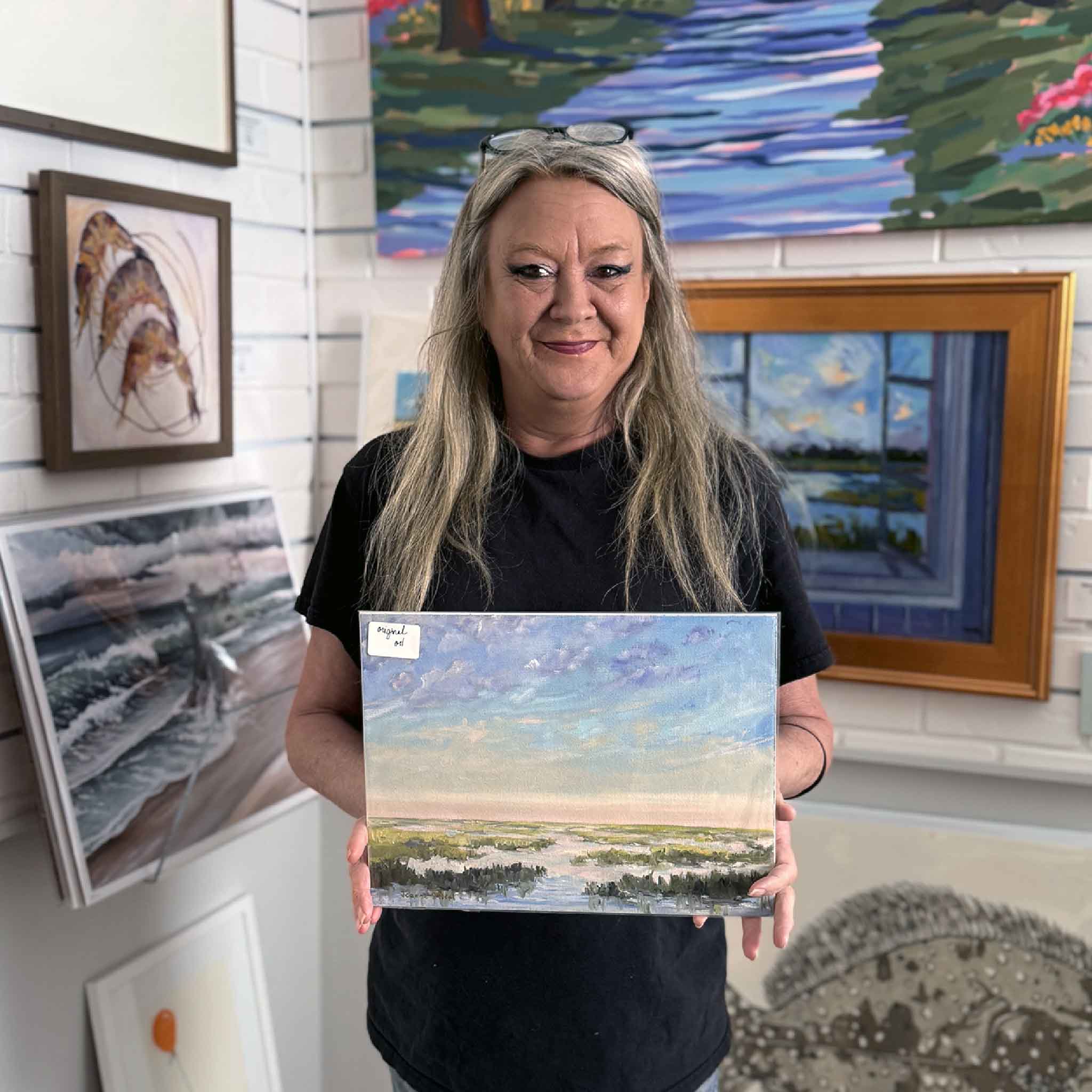 Charlotte holiding artist jeanne o’neal's salt and light #7 coastal marsh painting inside gray man gallery surrounded by lowcountry artwork