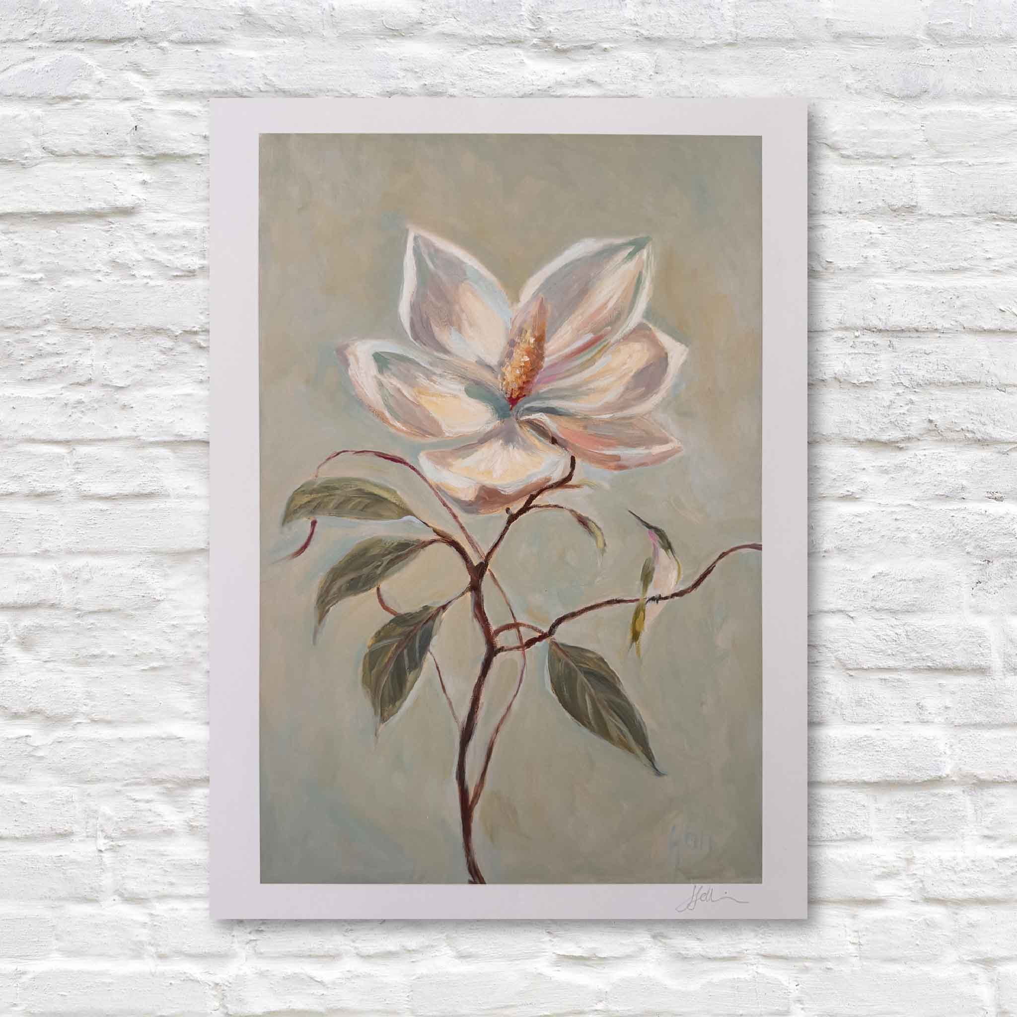 This image shows Helli Luck’s Southern Charm magnolia print in soft blush, cream, and sage tones, displayed against a white brick wall.