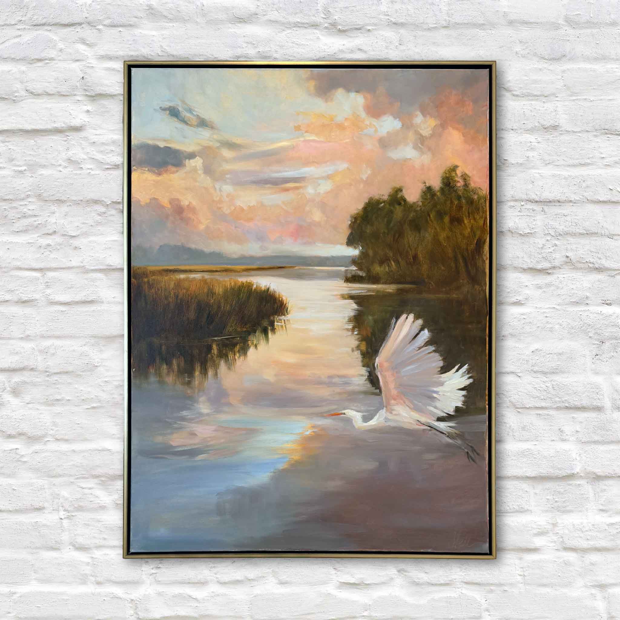 Sunset Cruise by local artist Helli Luck featuring a white egret lifting from calm marsh water at sunset with glowing peach and gold sky reflected across the Lowcountry landscape at Gray Man Gallery Pawleys Island
