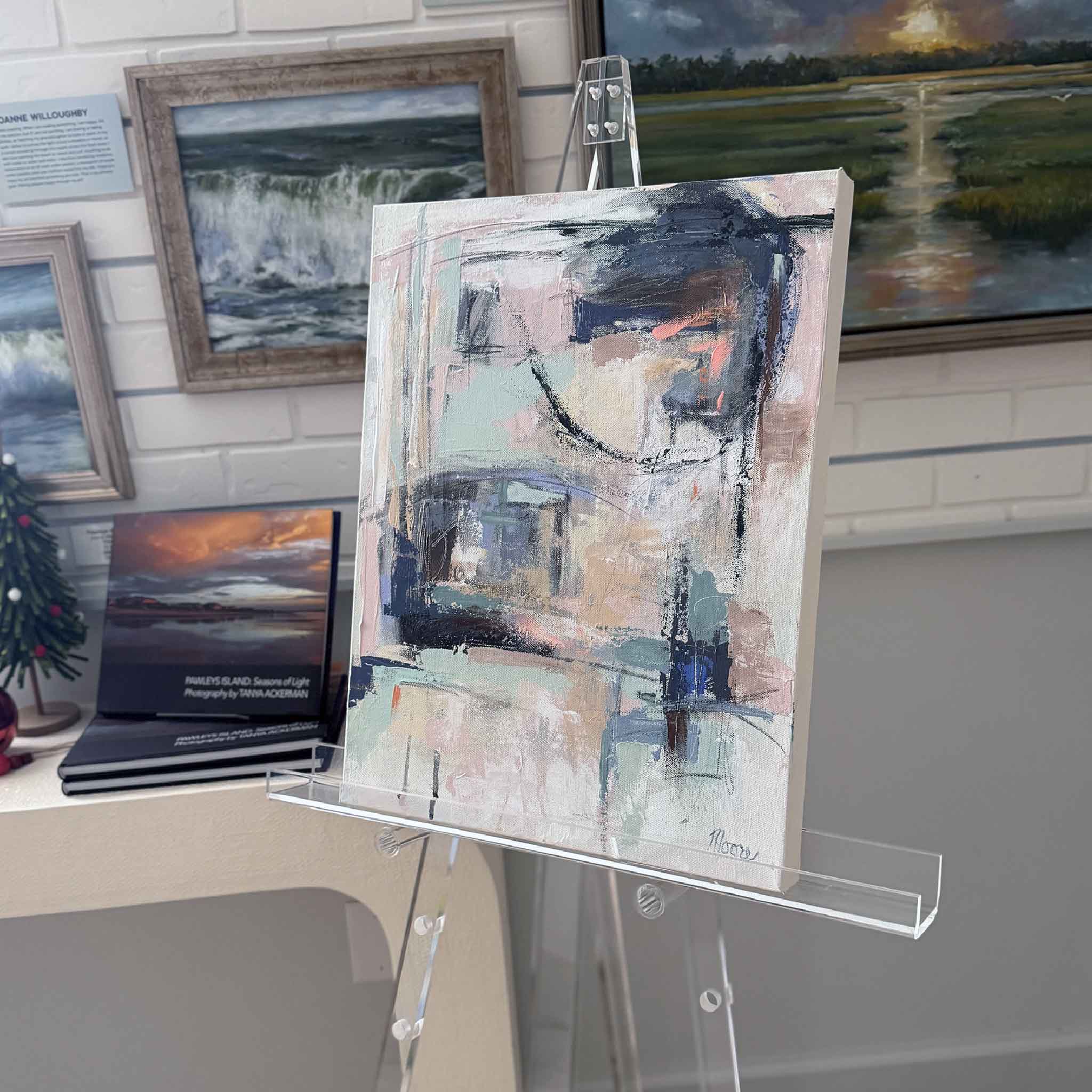 Original abstract painting “Sweet Dreams” by Susan Moore displayed on a clear easel inside Gray Man Gallery.