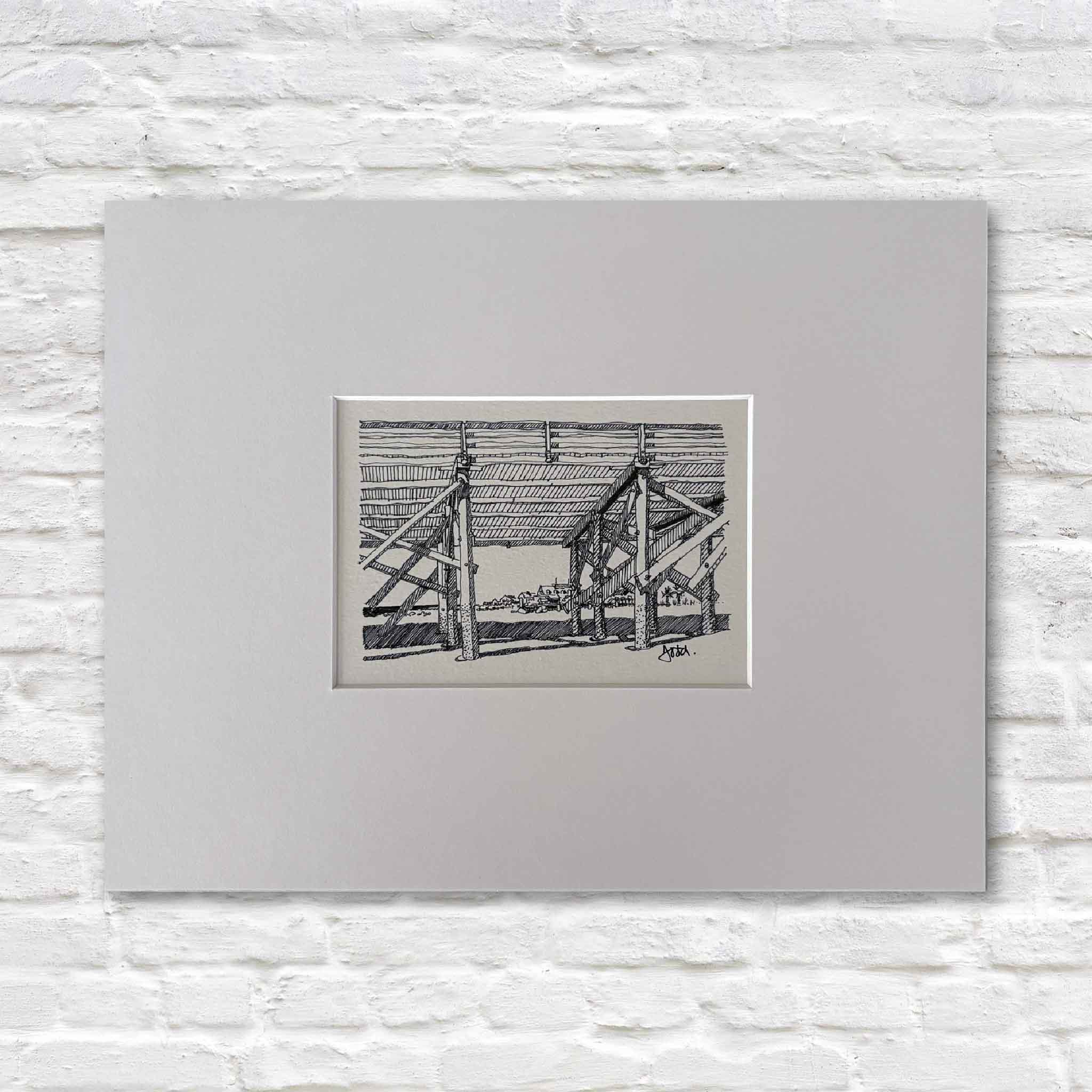 Todd Halamka's Beneath the Pawleys Pier pen-and-ink print, professionally matted to a standard 11x14 size and available at Gray Man Gallery in Pawleys Island, South Carolina. The detailed drawing captures the iconic structure beneath the historic Pawleys Island Pier and fits any standard 11x14 ready-made frame.