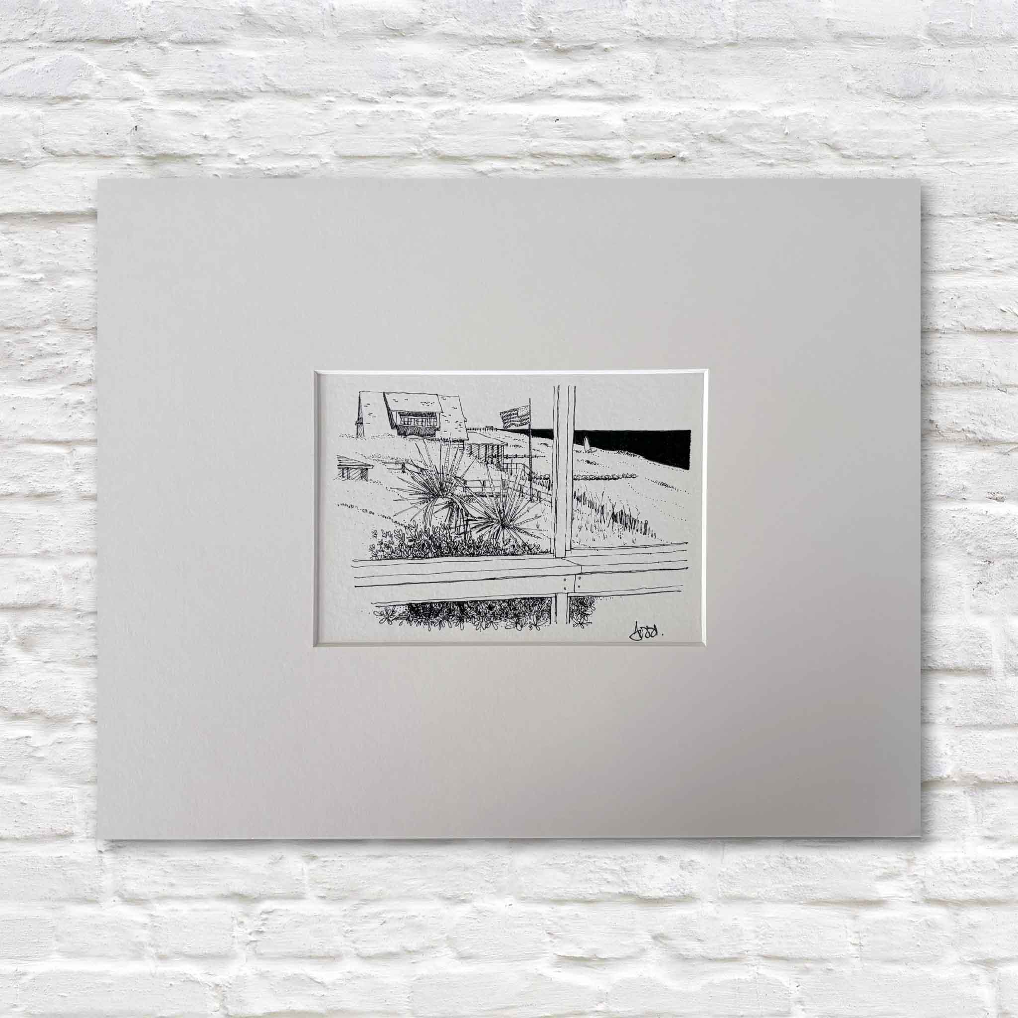 Todd Halamka's Fourth of July at Pawleys Island pen-and-ink print, professionally matted to a standard 11x14 size and available at Gray Man Gallery in Pawleys Island, South Carolina. This nostalgic illustration captures a classic Pawleys Island beach house with an American flag waving above the dunes, ready for any standard 11x14 frame.