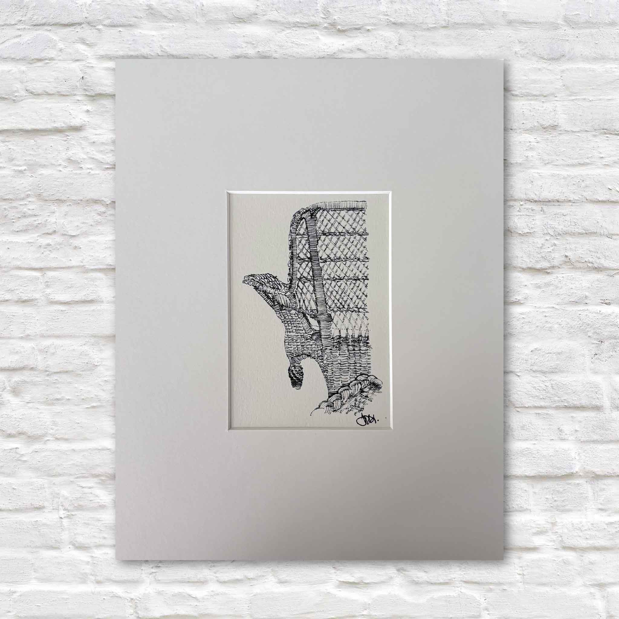 Fine art print titled Pawleys Island Wicker Chair by Pawleys Island artist Todd Halamka, professionally matted and available at Gray Man Gallery in Pawleys Island, South Carolina. Todd's detailed pen-and-ink illustration captures the iconic woven wicker porch chair found on generations of Pawleys Island beach houses. The print is matted to fit a standard ready-made frame, so no custom framing is required.