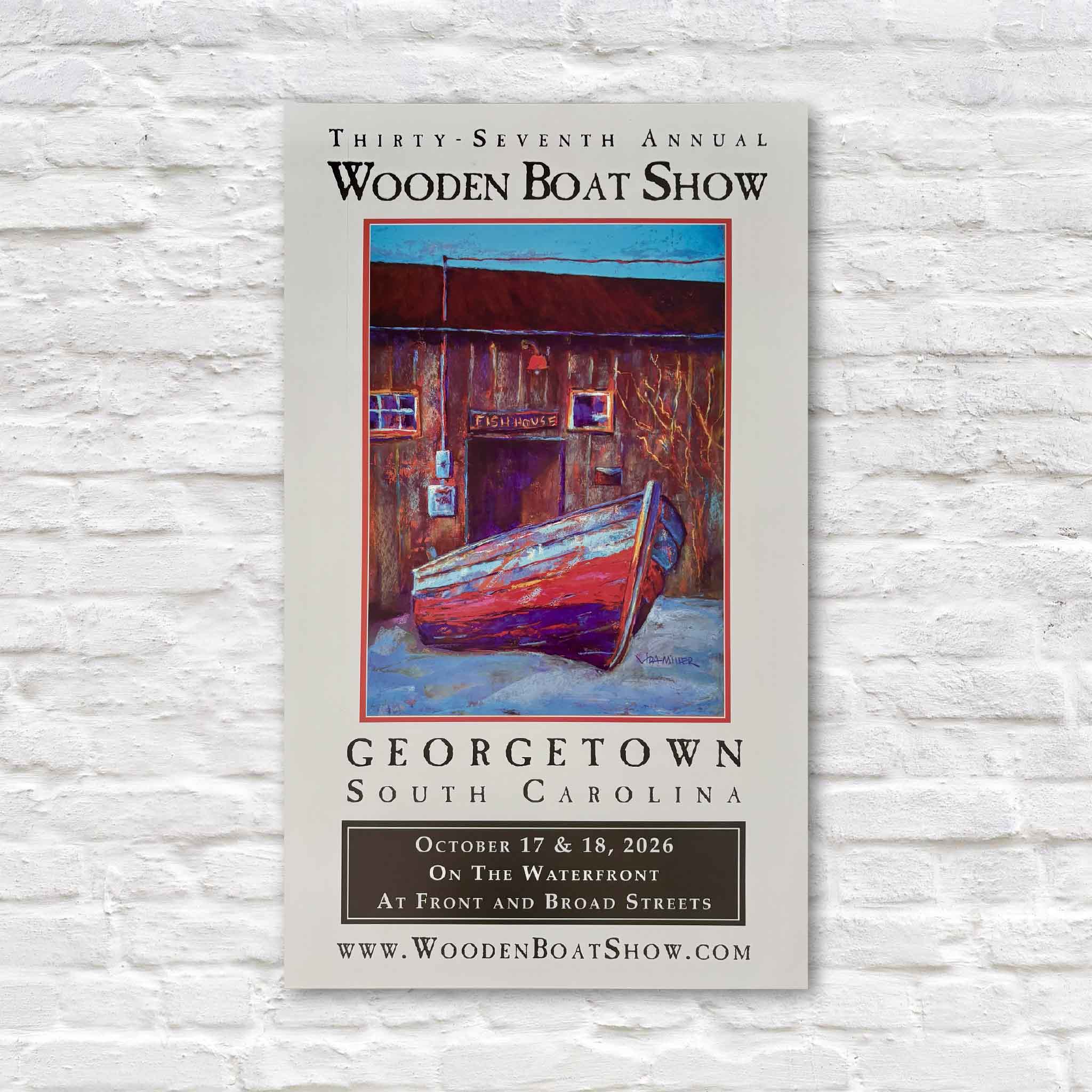 Official signed 2026 Georgetown Wooden Boat Show poster featuring original artwork by South Carolina artist Vida Miller of the historic Cathou Fish House on the Georgetown waterfront, with a colorful wooden boat in the foreground. Personally signed by Miller and available at Gray Man Gallery in Pawleys Island, South Carolina.