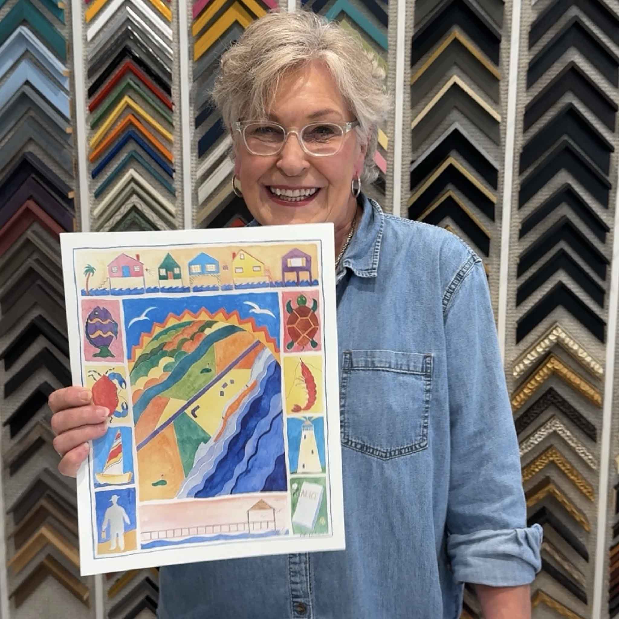 Local artist Vida Miller holding her signed Pawleys Island Poster at Gray Man Gallery in Pawleys Island, South Carolina. The colorful design celebrates the island's cottages, wildlife, maritime history, and the legendary Gray Man.