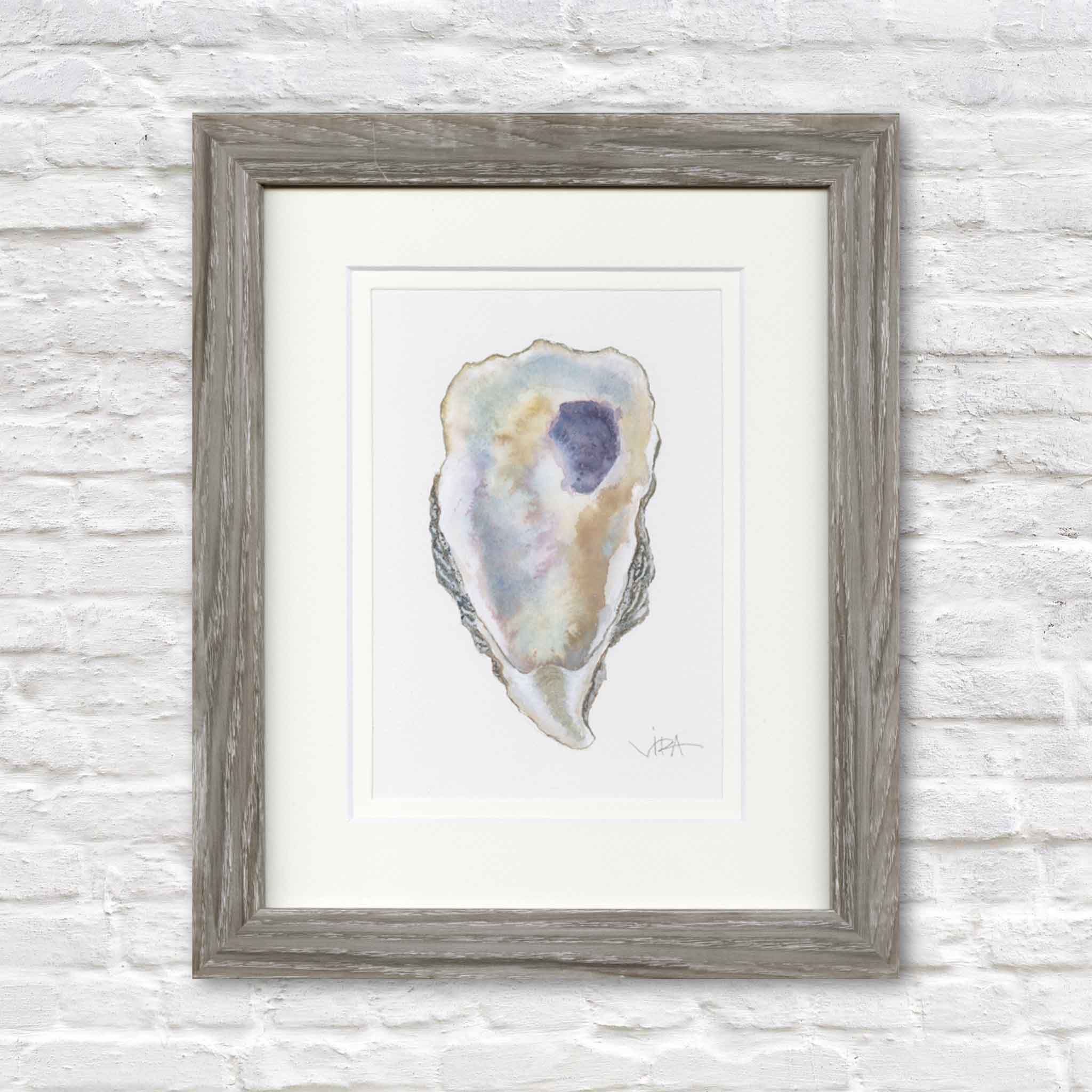 Original watercolor painting, Pawleys Oyster Shell VI by Pawleys Island artist Vida Miller, professionally double matted and framed in a weathered gray wood frame. This one-of-a-kind oyster shell features soft pearl whites, gentle blues, warm sandy golds, and a striking lavender-purple interior accent, creating an elegant piece of coastal artwork available at Gray Man Gallery in Pawleys Island, South Carolina.