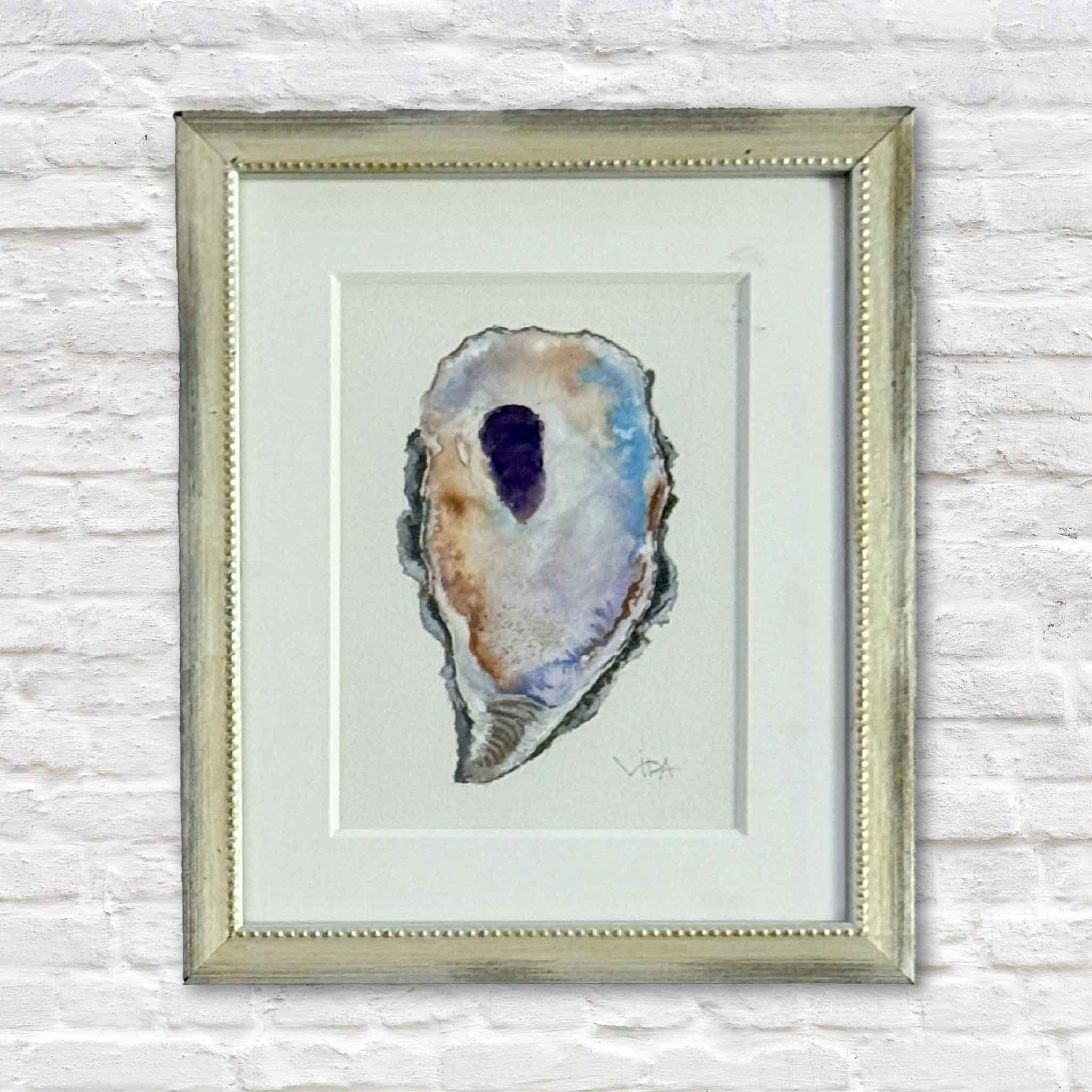 Pawleys Oyster VII original watercolor painting by Pawleys Island artist Vida Miller, featuring a single Lowcountry oyster shell in violet, lavender, blue, cream, rust, and gray, professionally matted and framed in a softly antiqued metallic beaded frame at Gray Man Gallery in Pawleys Island, South Carolina.