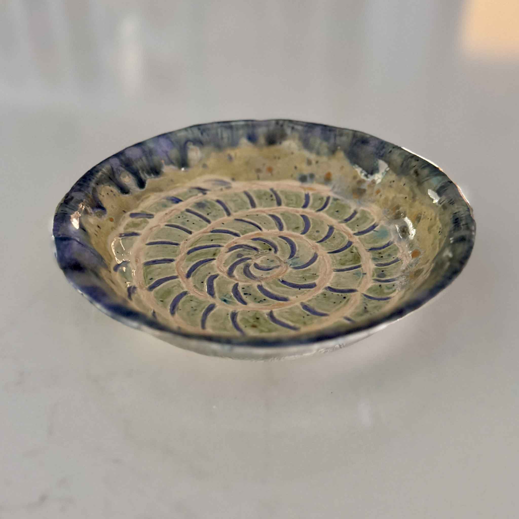 Angled view of Sea Life Spiral Dish by Vida Miller showing layered spiral carving and coastal-inspired glaze at Gray Man Gallery