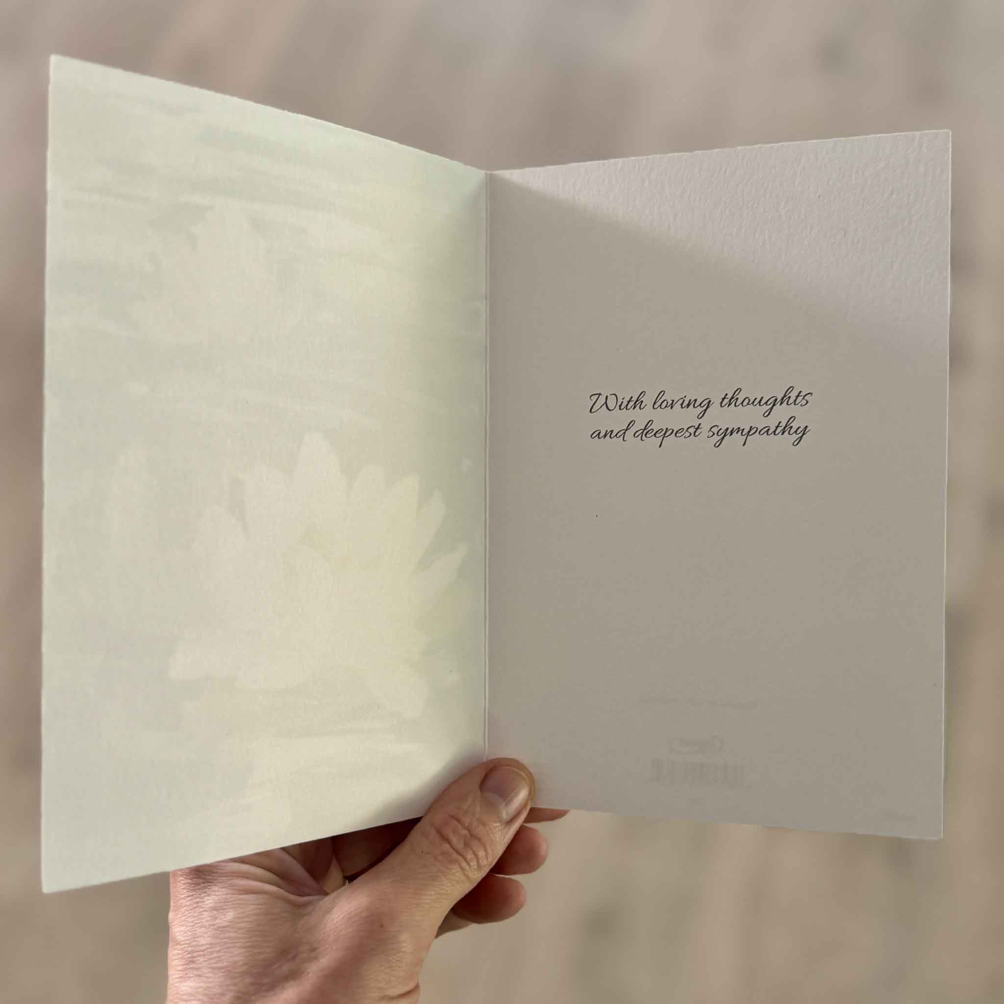 Inside of Caspari's Water Lilies sympathy greeting card featuring the printed sentiment, "With loving thoughts and deepest sympathy," alongside a softly printed water lily illustration on premium heavyweight cardstock. Available at Gray Man Gallery in Pawleys Island, South Carolina.