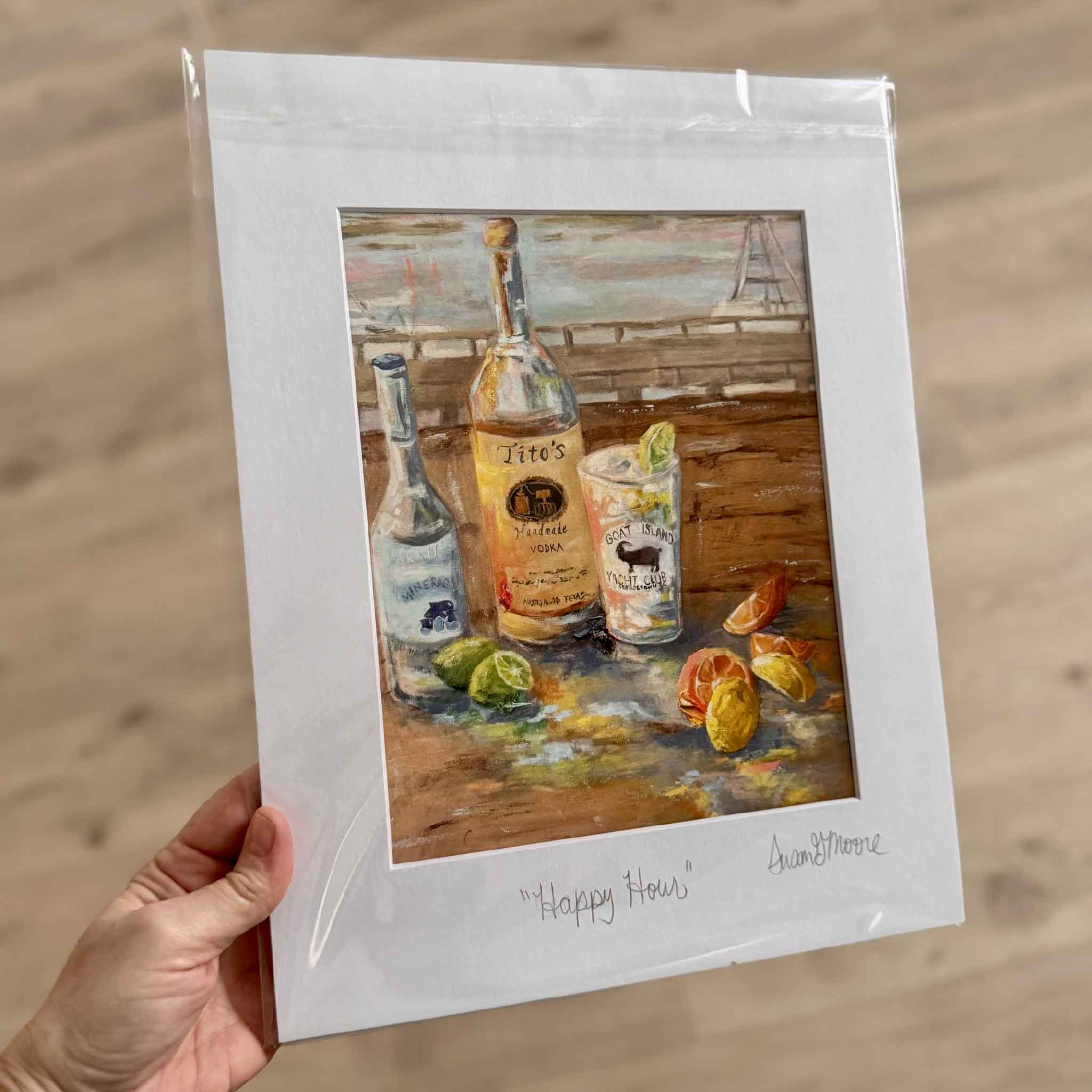 11x14 matted fine art giclée print Happy Hour by Susan Moore featuring a Tito’s vodka bottle, Goat Island Yacht Club glass, and limes on a dockside table.