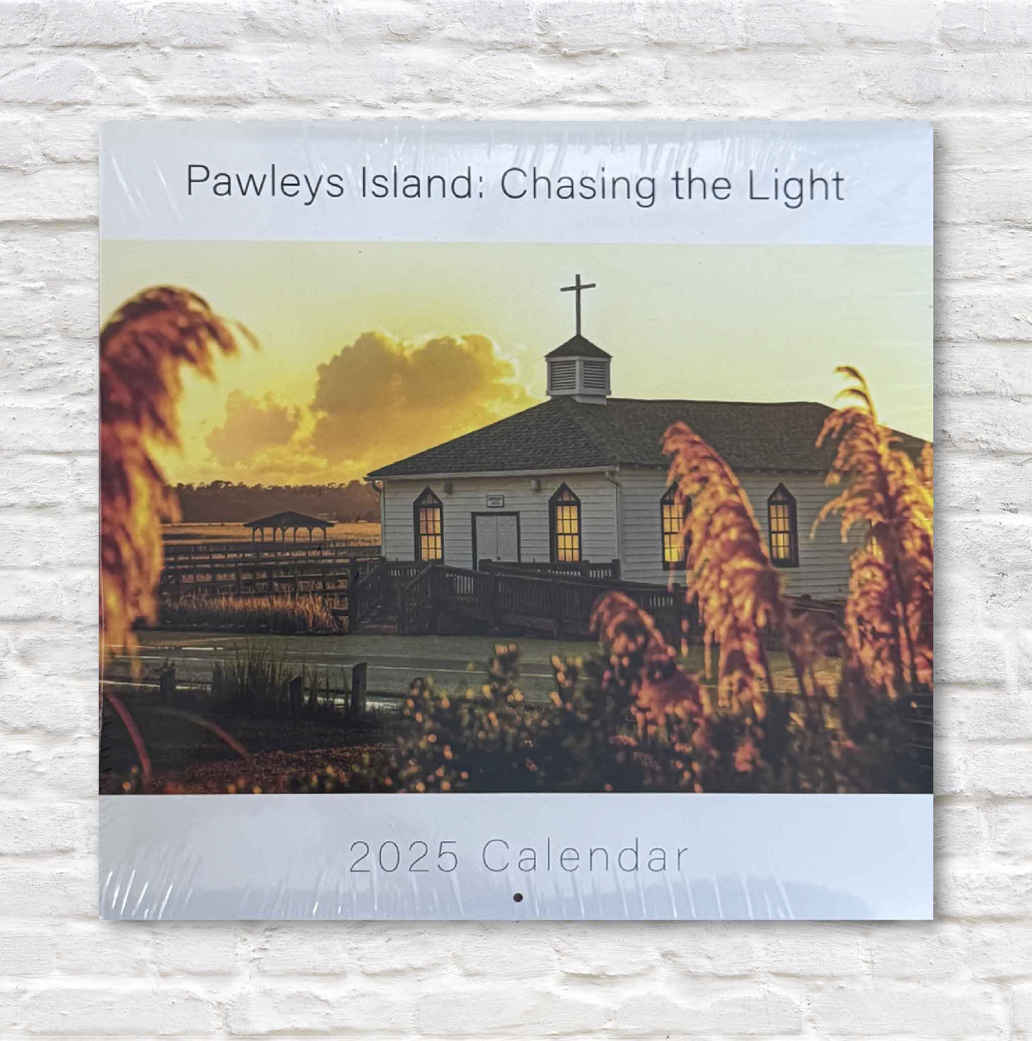 2025 calendar cover featuring a church and sunset over water with 'Pawleys Island: Chasing the Light' text.