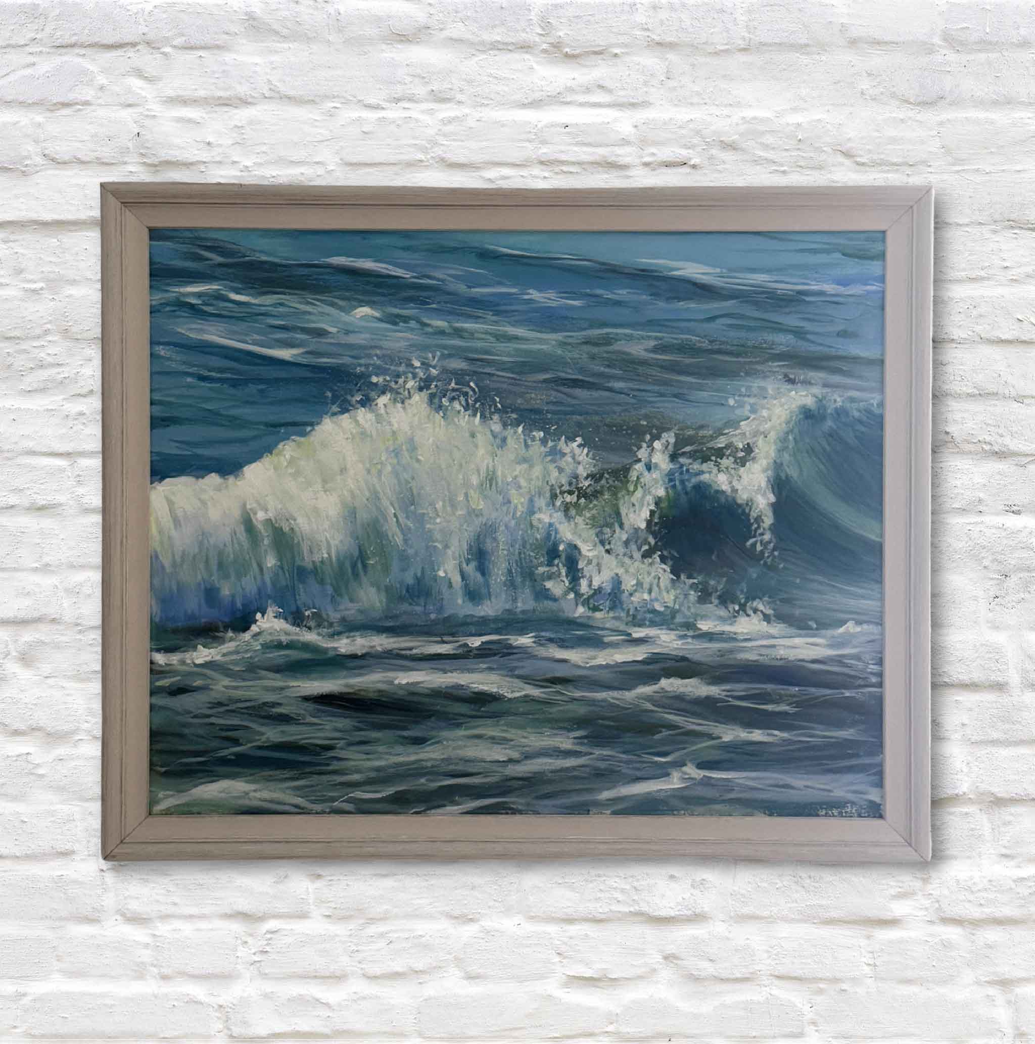 Framed painting of ocean waves on a white brick wall