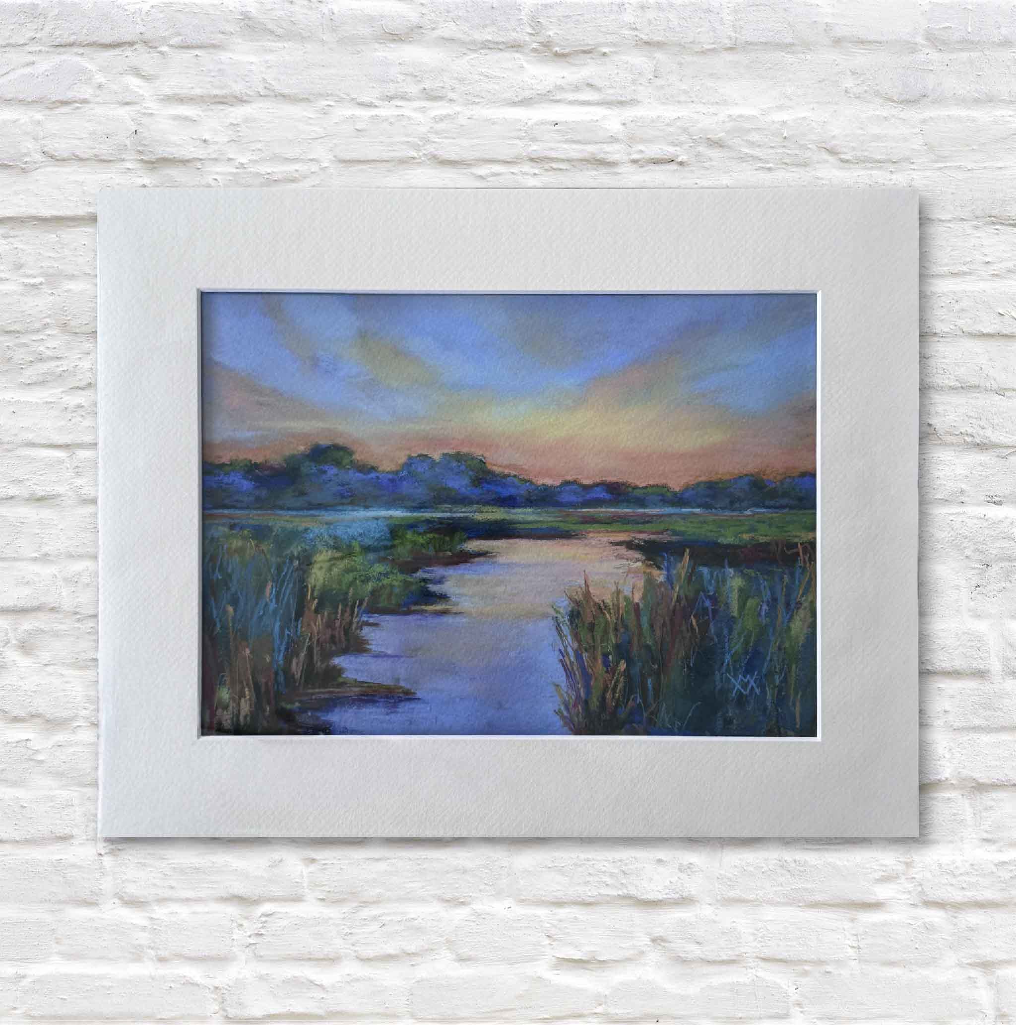 matted painting of a marsh landscape with a river and trees on a white brick wall.