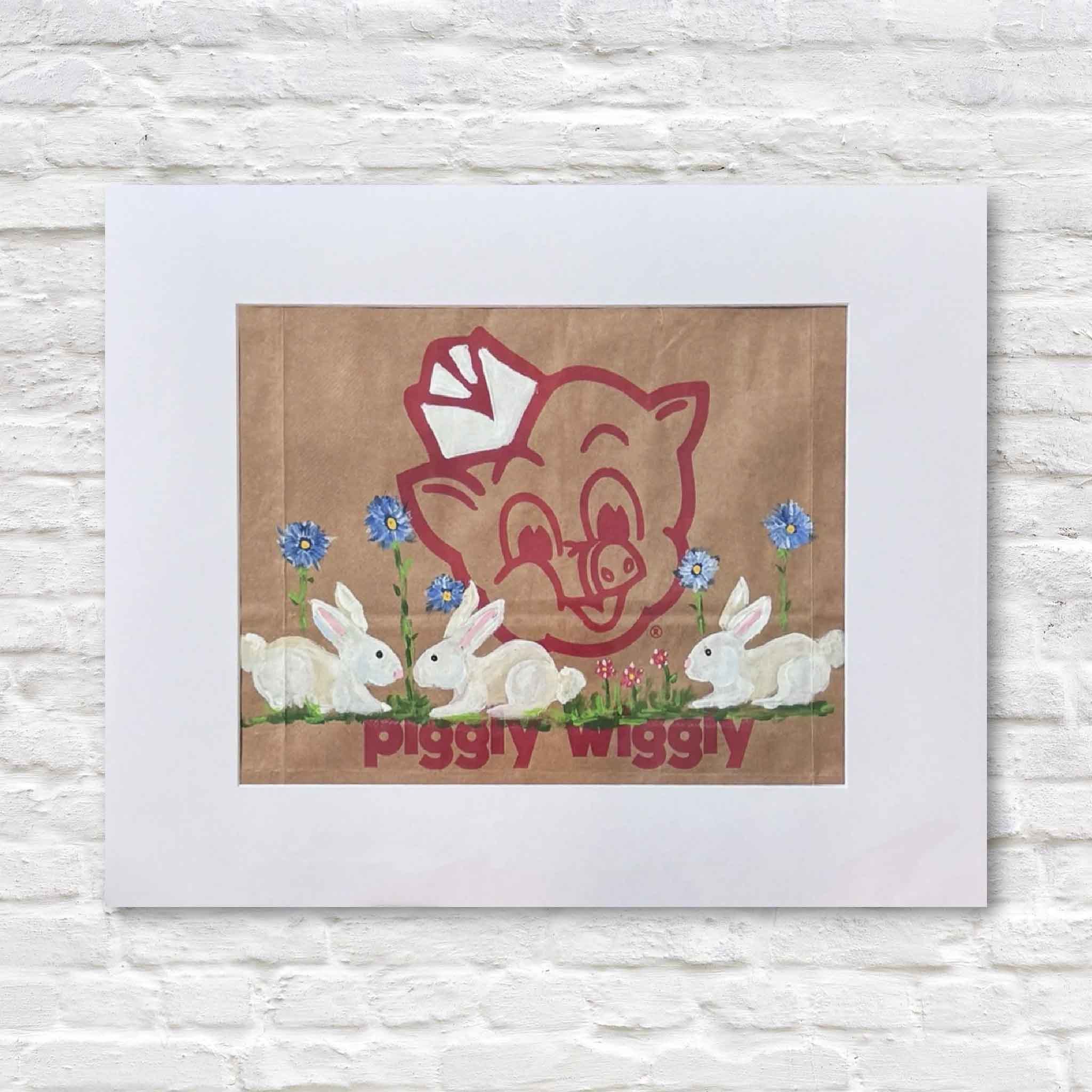 matted artwork of a pig logo with rabbits and flowers, labeled 'Piggly Wiggly', on a textured white background.