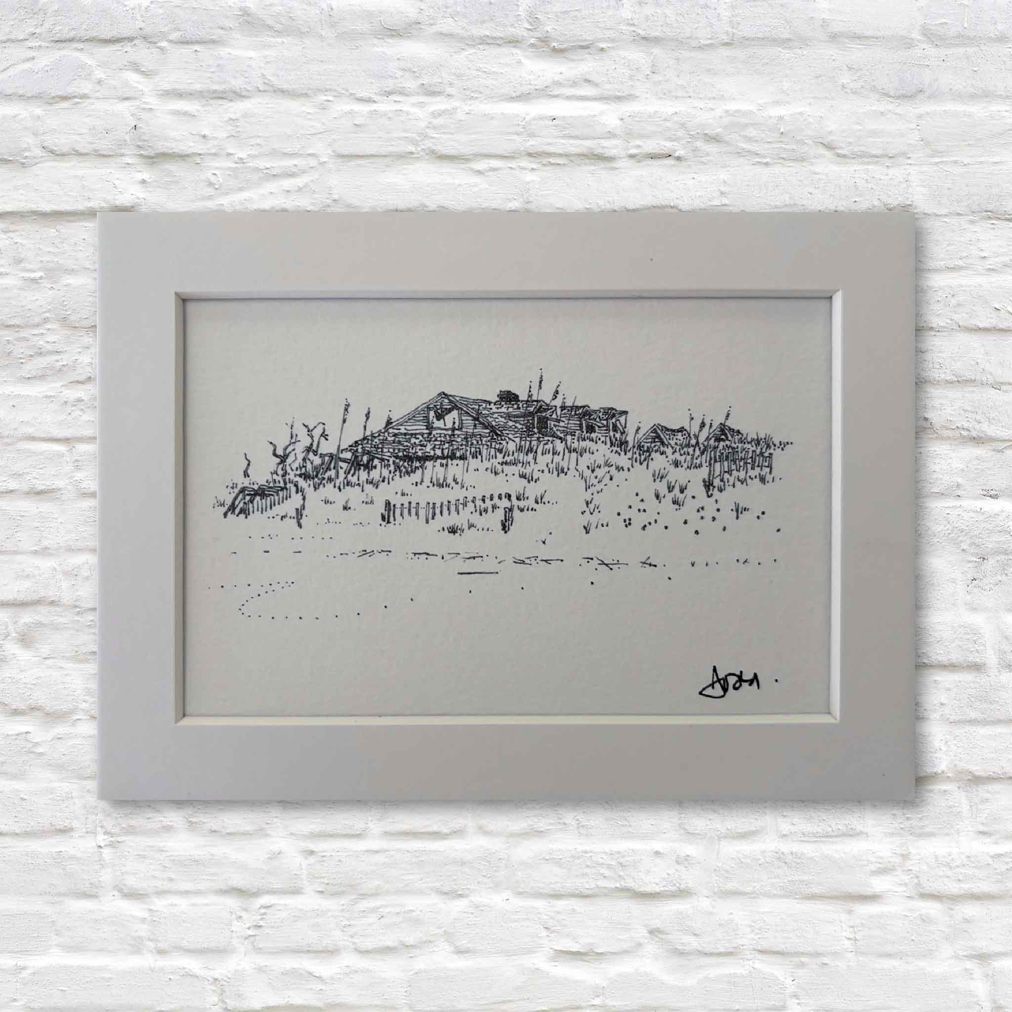 matted black and white drawing of a coastal scene on a textured white wall.