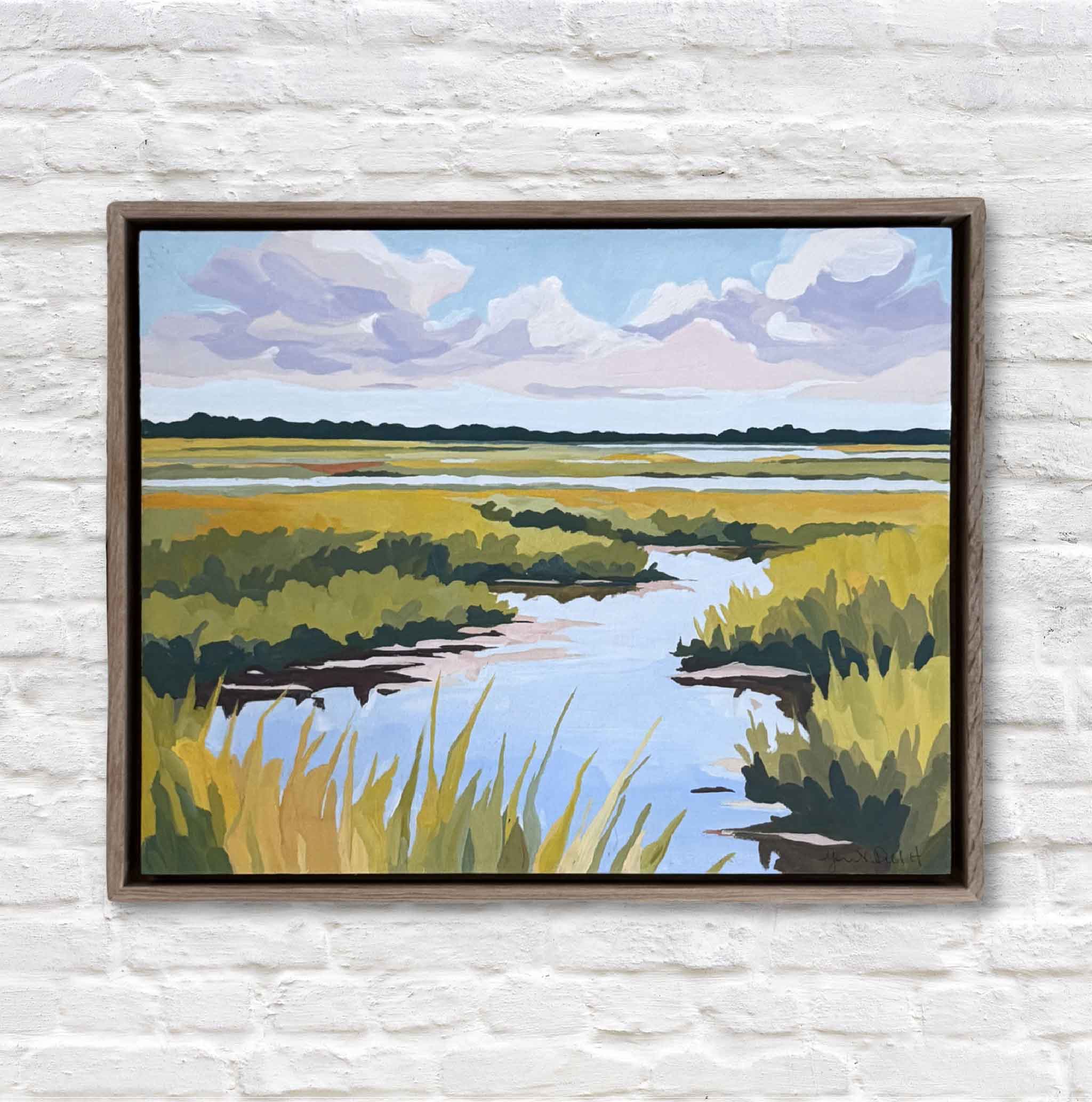 Framed painting of a marsh landscape with a river and greenery on a white brick wall.