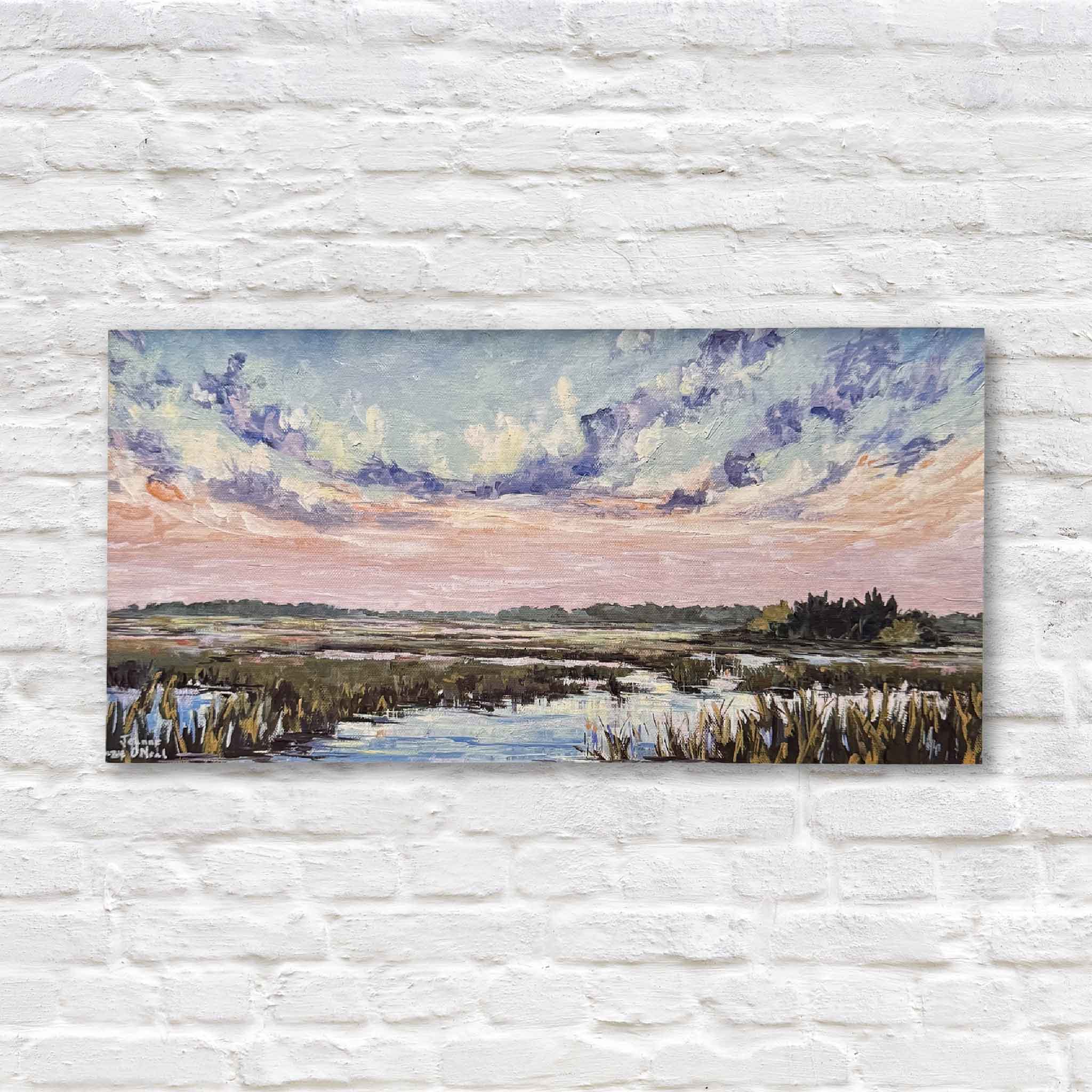 his fine art giclée print, created from Jeanne O’Neal’s original painting, features soft pinks, purples, and blues dancing across a reflective waterway and rippling clouds over the lowcountry marsh