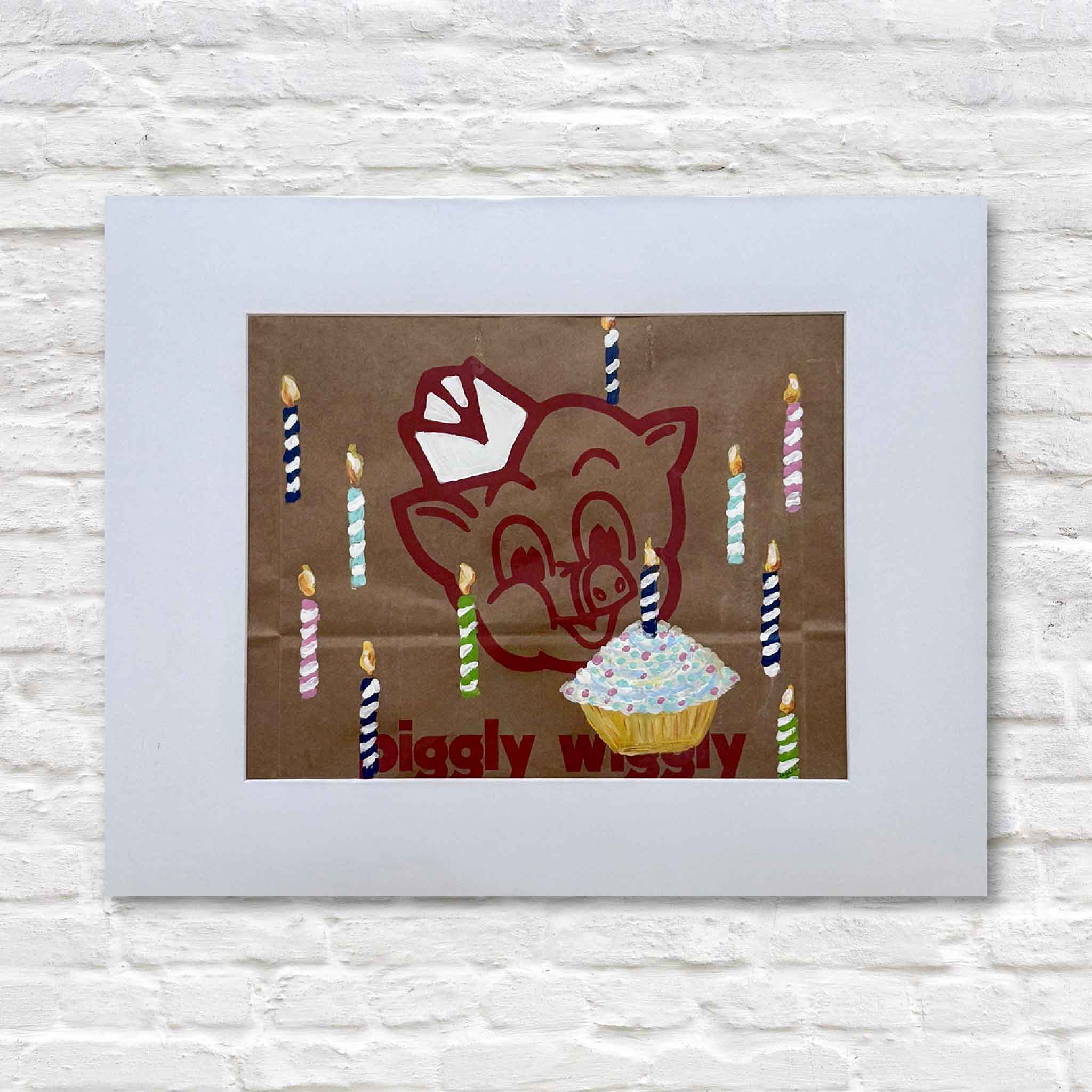Illustration of a cartoon pig with candles and a cupcake on a brown background, framed against a white brick wall.
