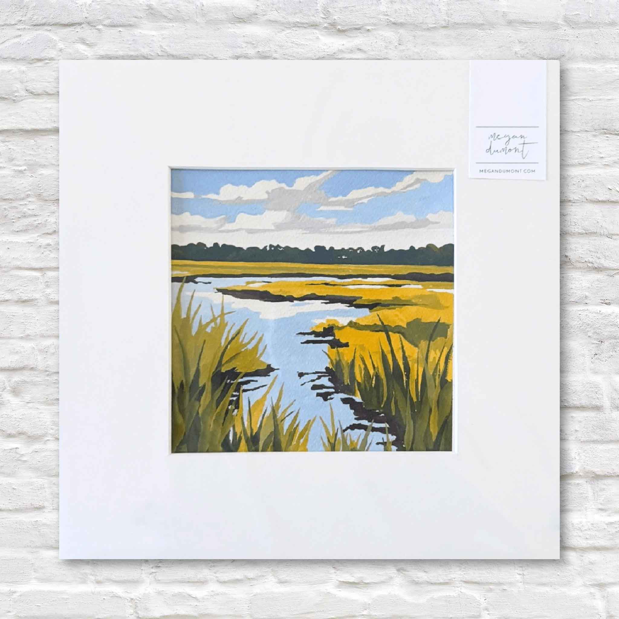 matted artwork of a marsh landscape with yellow grass and blue water on a white wall.