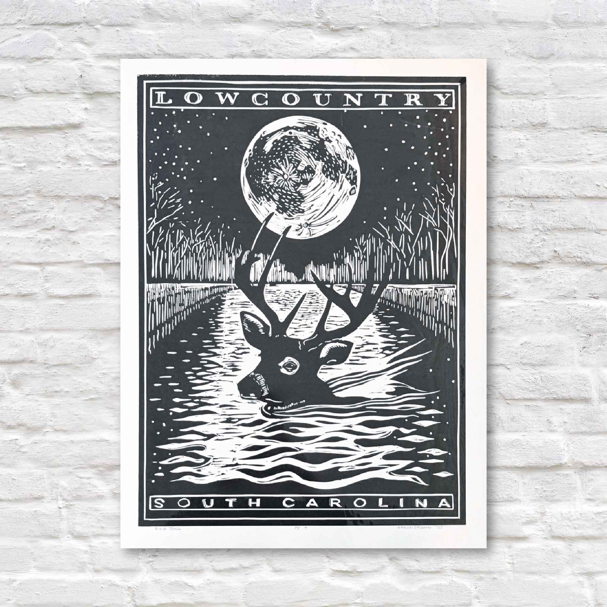 linocut with a deer and moon design on a white brick wall background
