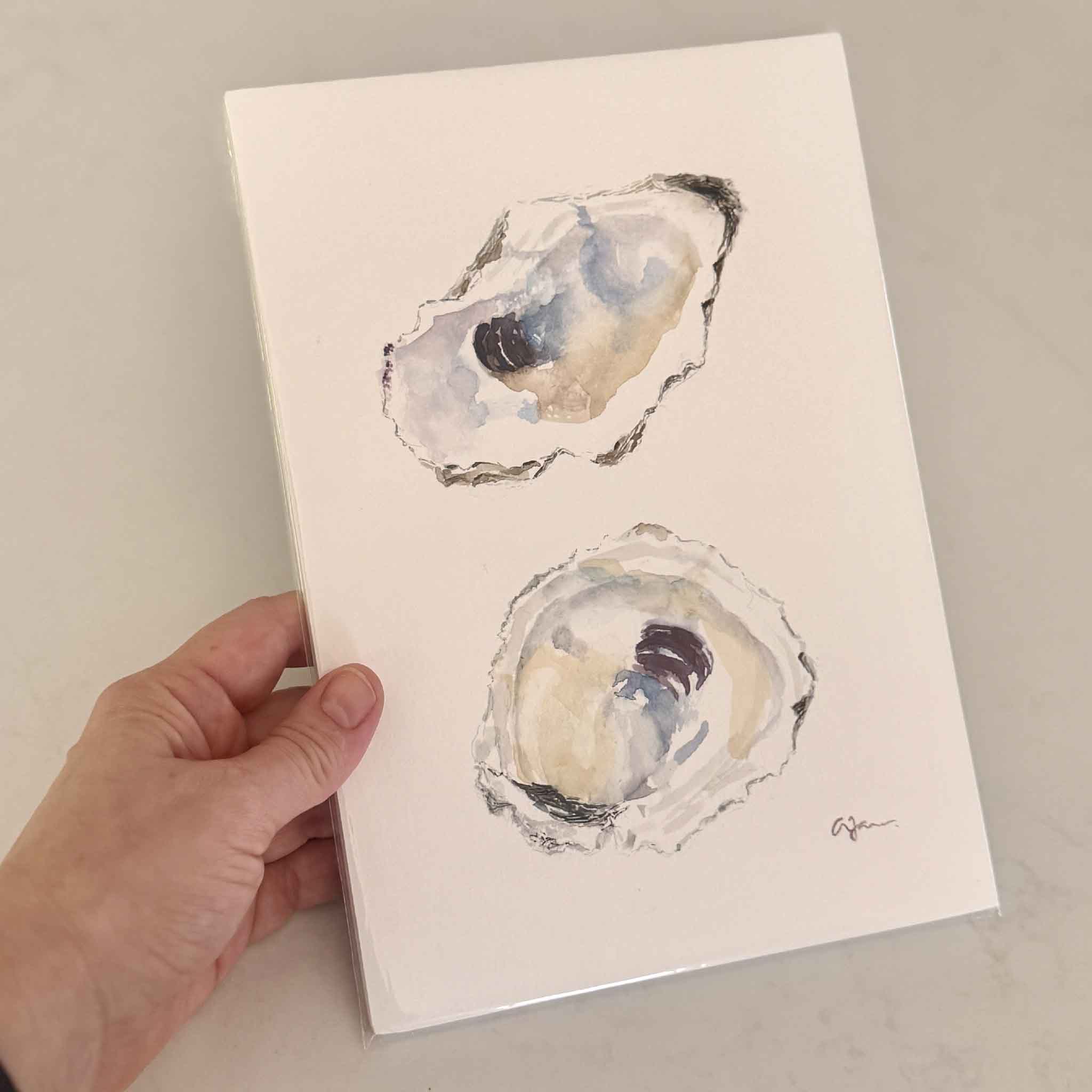 Hand-painted and signed watercolor artwork of two oyster shells in blue and sandy neutrals by artist Allison Farr, from the Lowcountry Jewels oyster series.