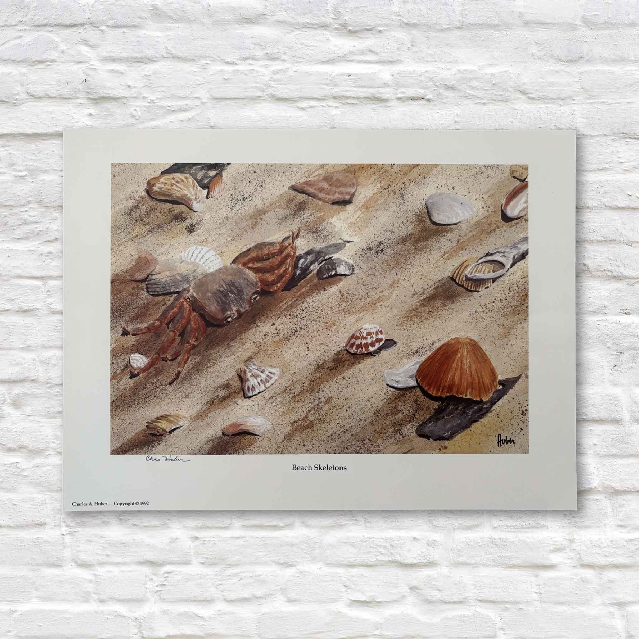 artwork of a crab and shells on a sandy beach against a white brick wall.