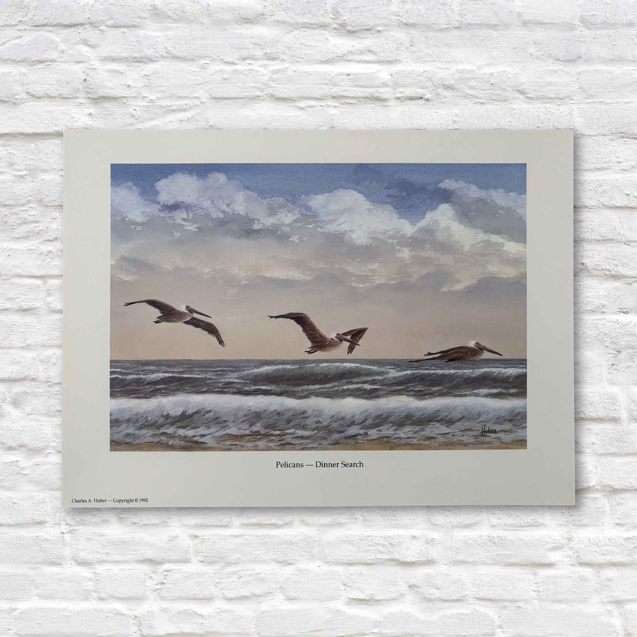 artwork of pelicans over water with a cloudy sky on a white brick wall.