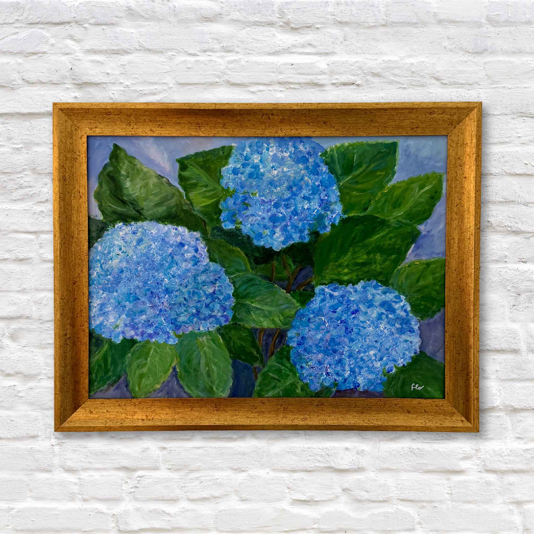 Framed painting of blue hydrangeas on a white brick wall
