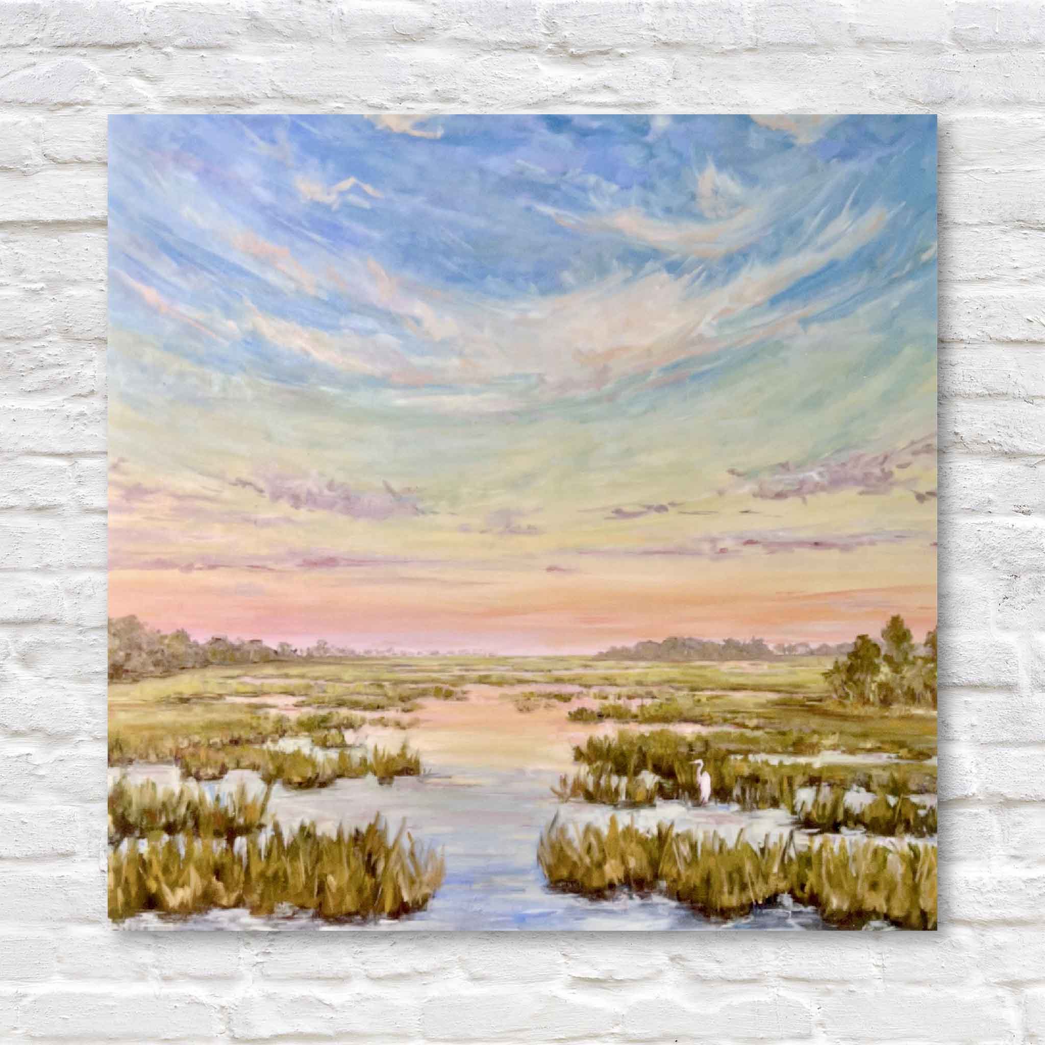 Painting of a marsh landscape with a colorful sky on a white brick wall.