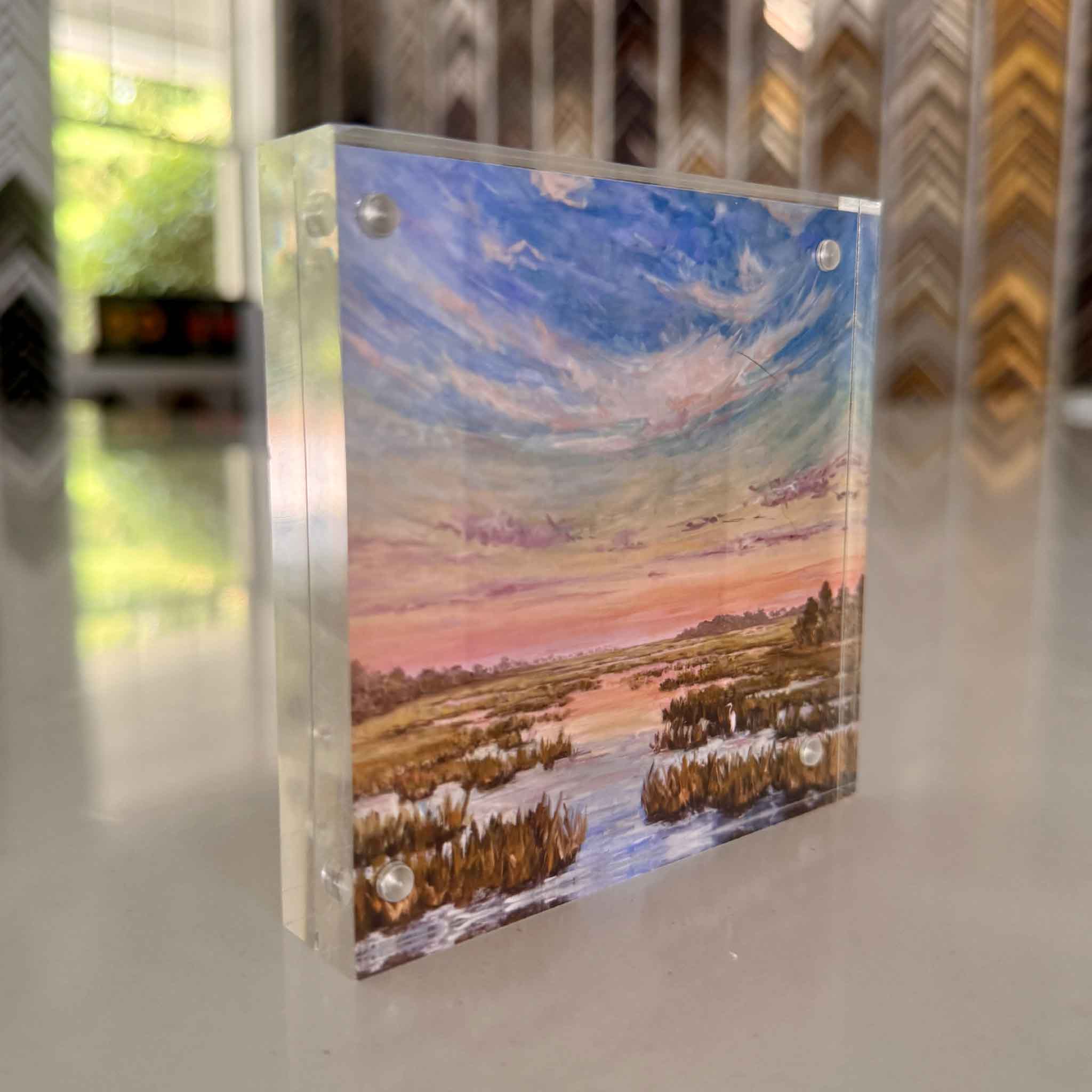 Acrylic block with a landscape painting of a sunset over water and lowcountry marsh.