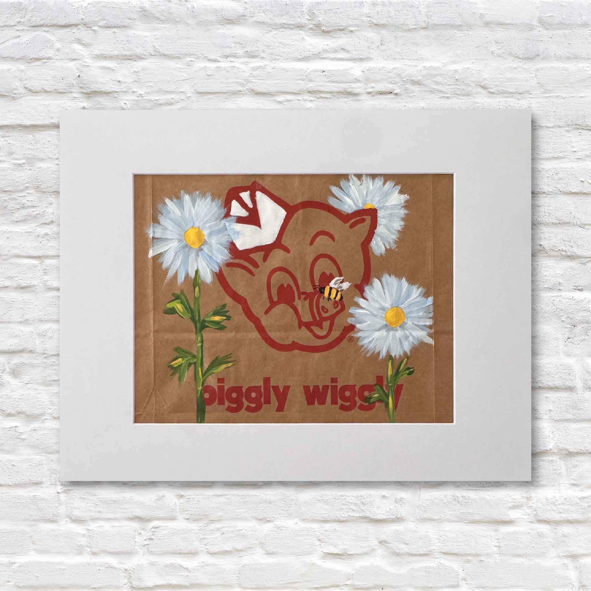 Mixed media artwork of acrylic painting of a daisy flowers and a bumble bee on a Piggly Wiggly shopping bag in a white matte against a white brick wall