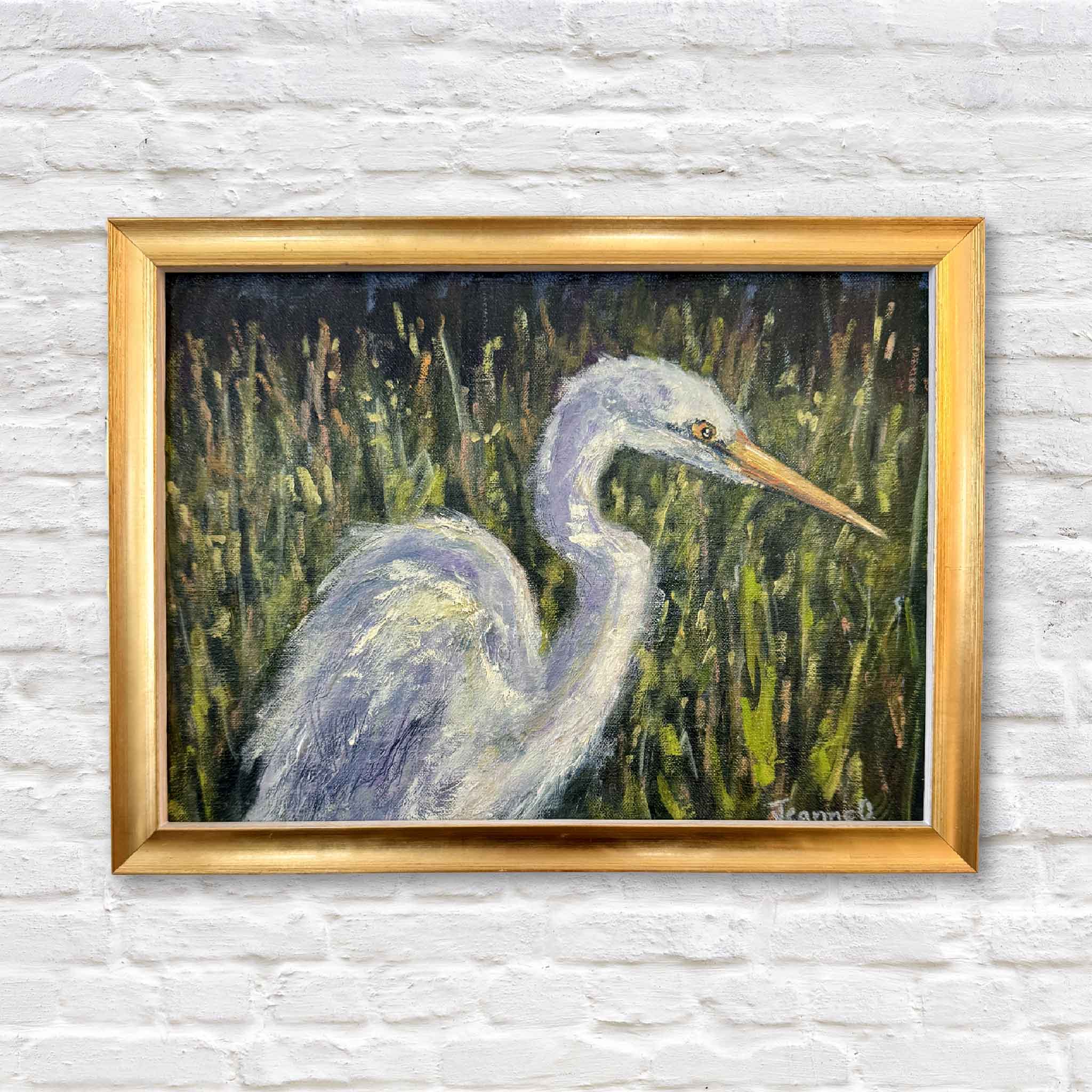 Original oil painting of an egret in a Lowcountry marsh in a gold frame against a white brick wall