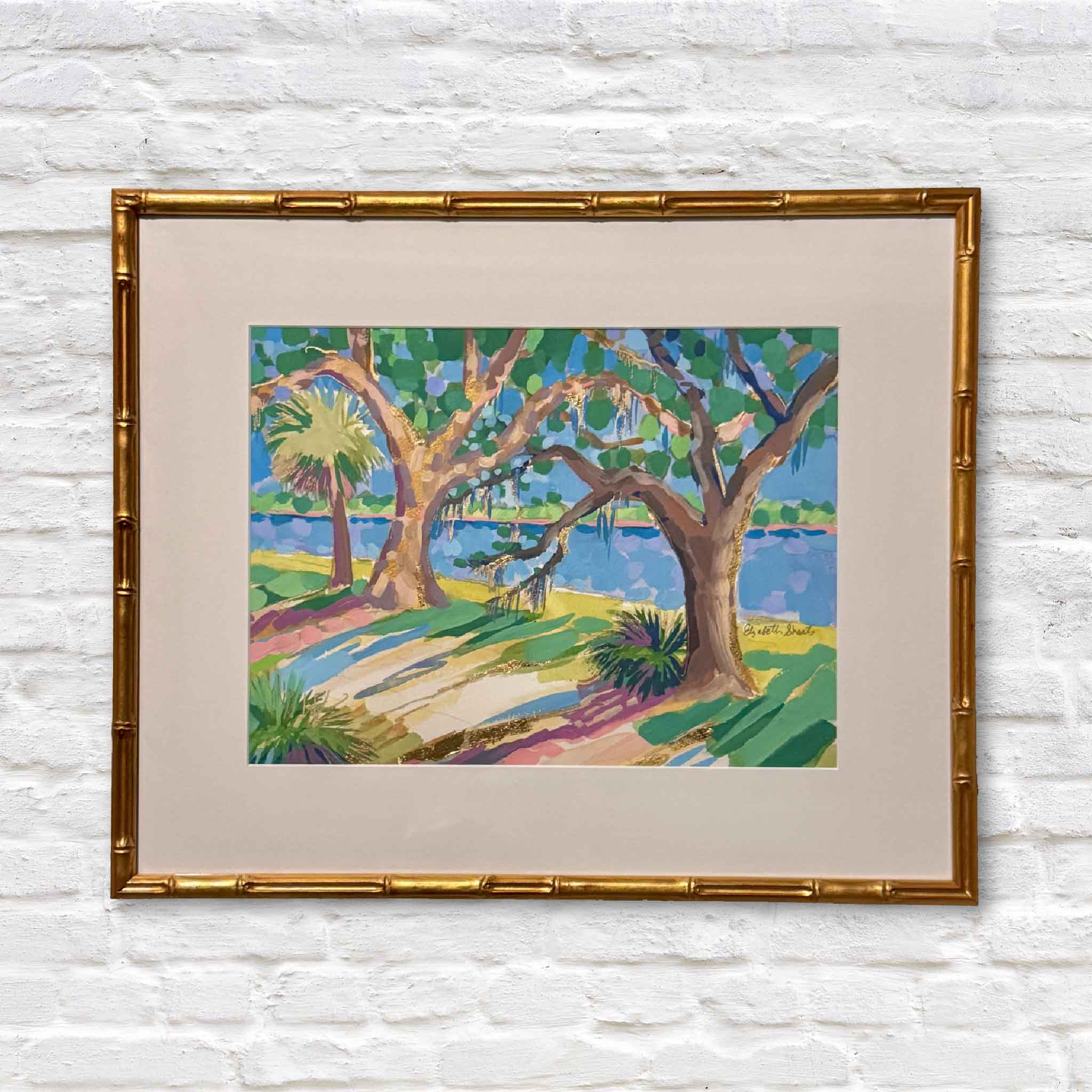 Bamboo gold framed mixed media artwork of colorful lowcountry trees on a white brick wall