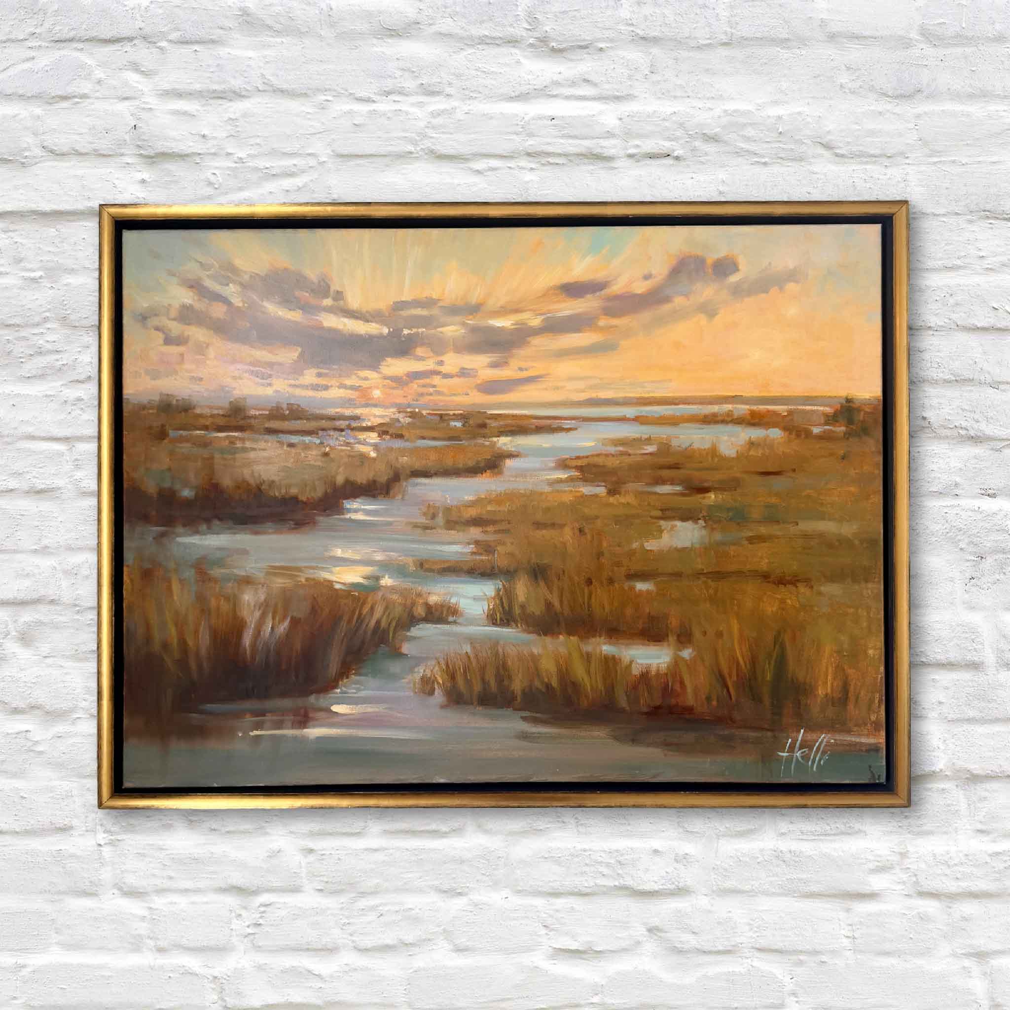 Framed painting of a landscape with water and sky on a white brick wall