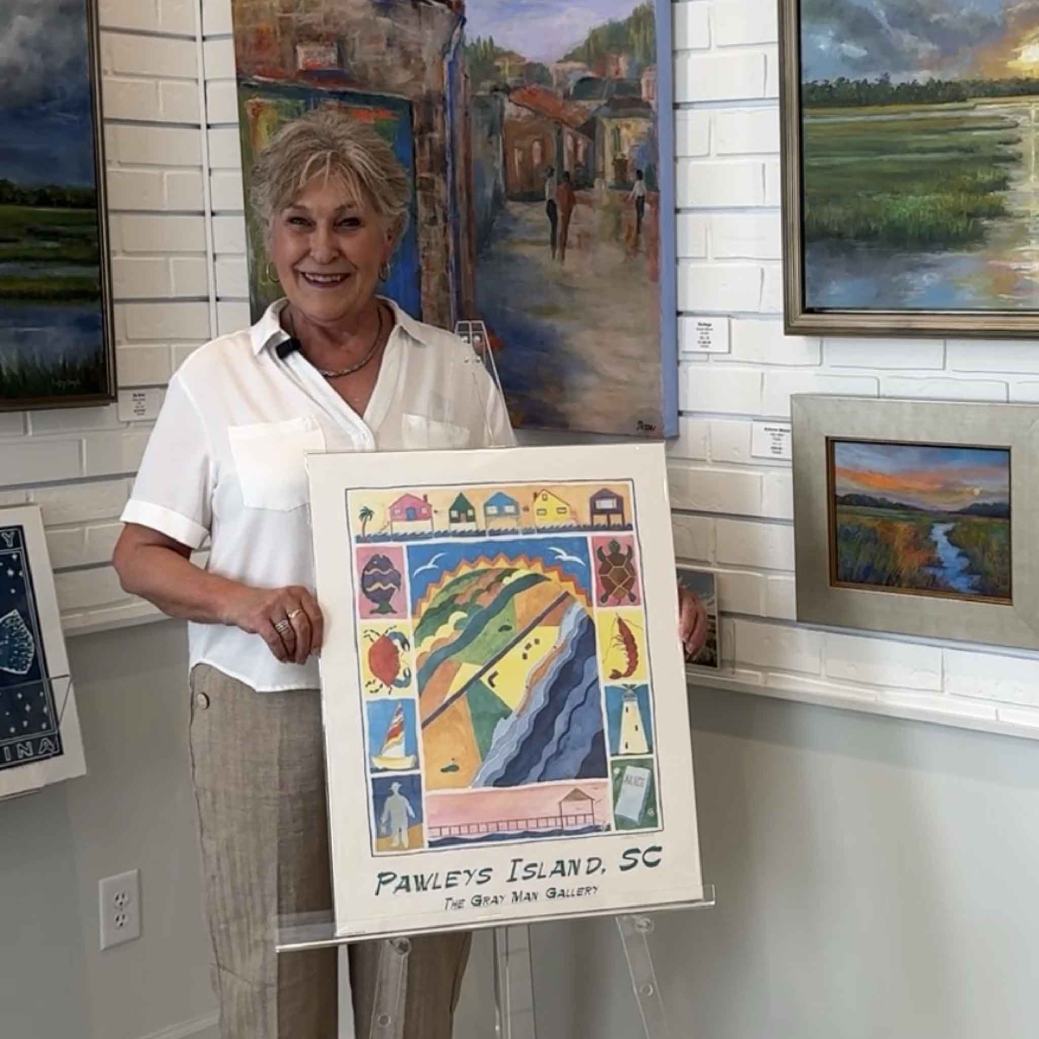 Vida holding a her famous Pawleys Island, SC poster at Gray Man Gallery 