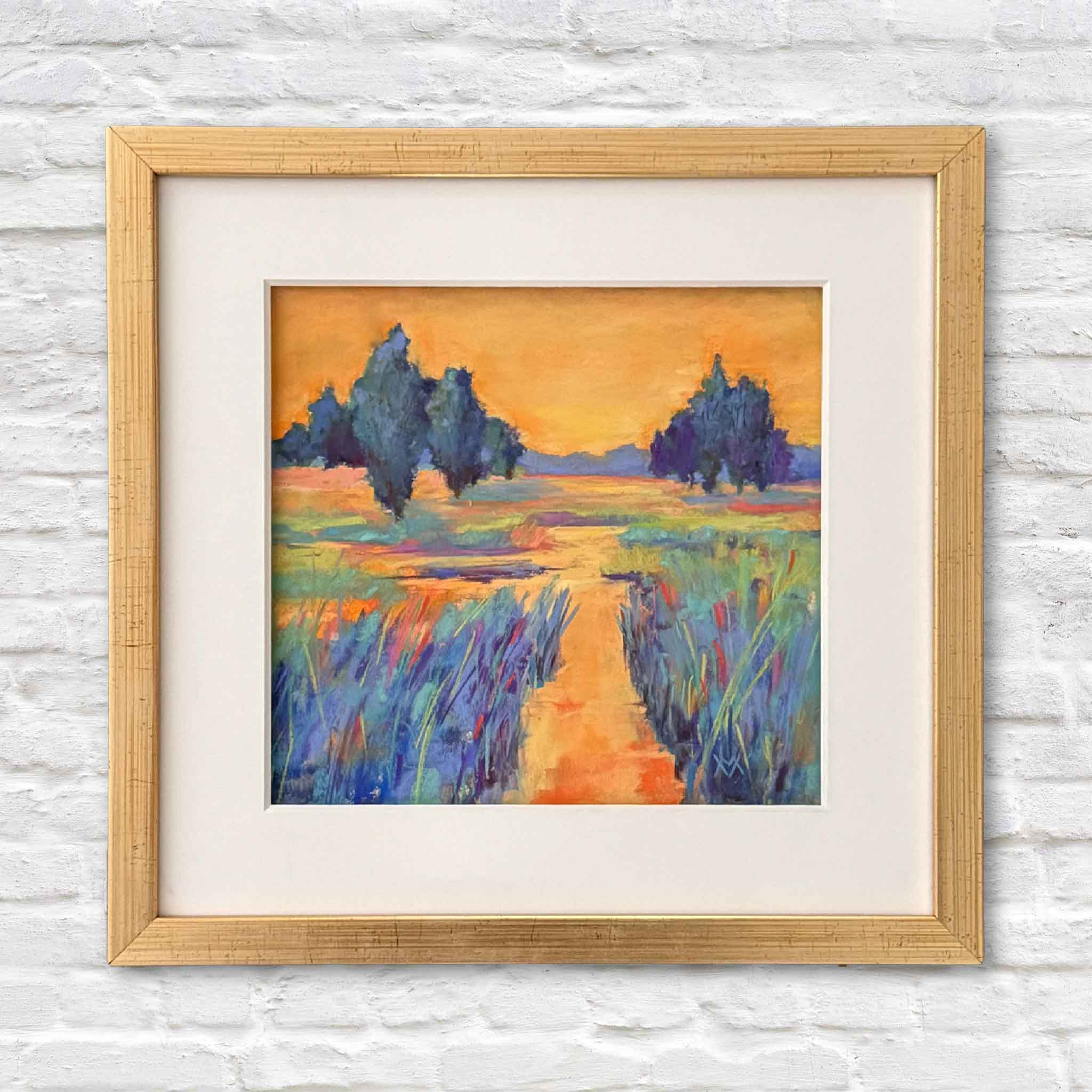 Framed painting of a landscape with trees and a path on a white brick wall.