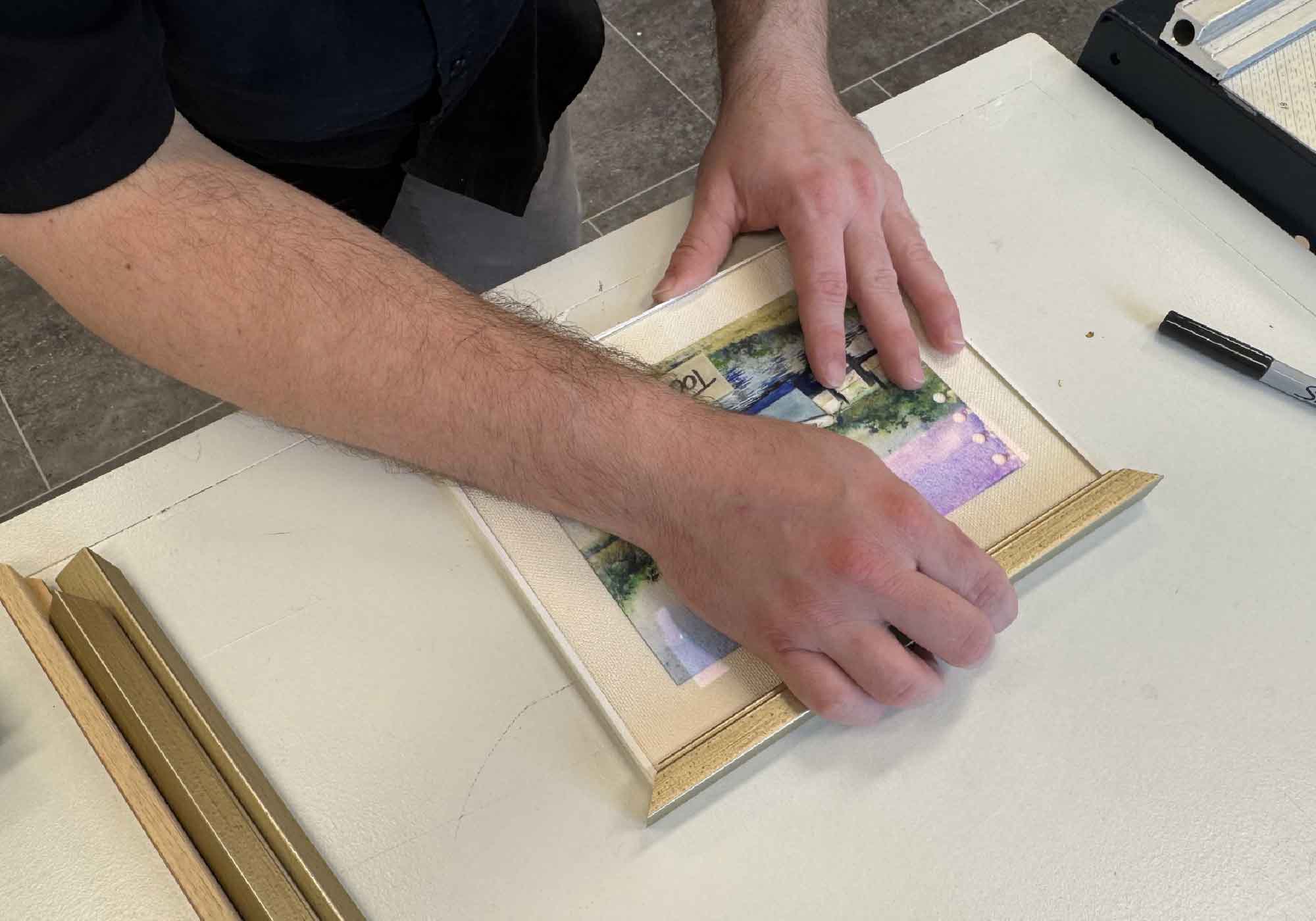 Custom framing in progress at Gray Man Gallery, showcasing expert craftsmanship and attention to detail.