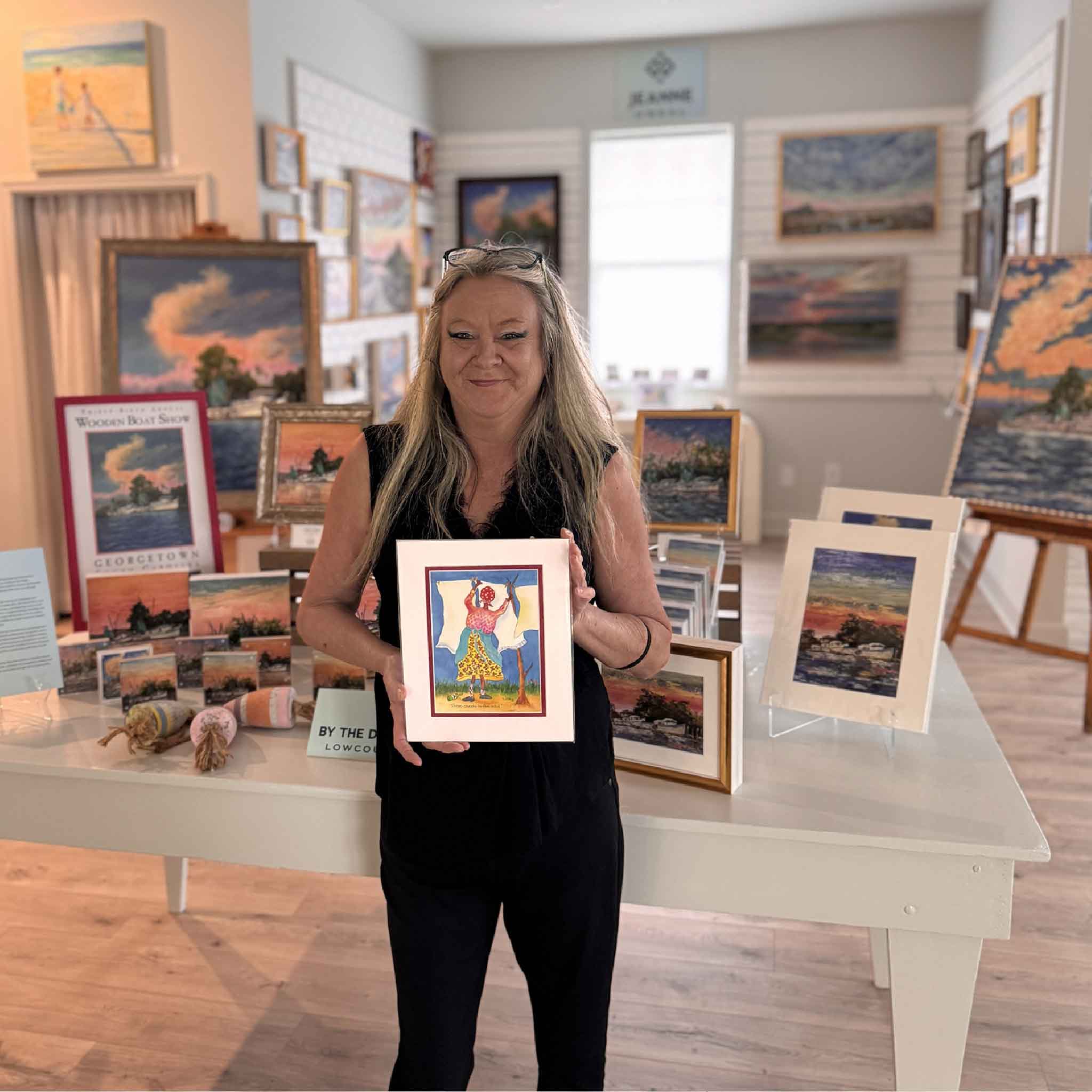 Vida Miller’s “Three Sheets to the Wind” Little Ladies print, matted to 8x10, featuring a woman hanging sheets on a clothesline in a breezy Lowcountry scene. Pictured at Gray Man Gallery.