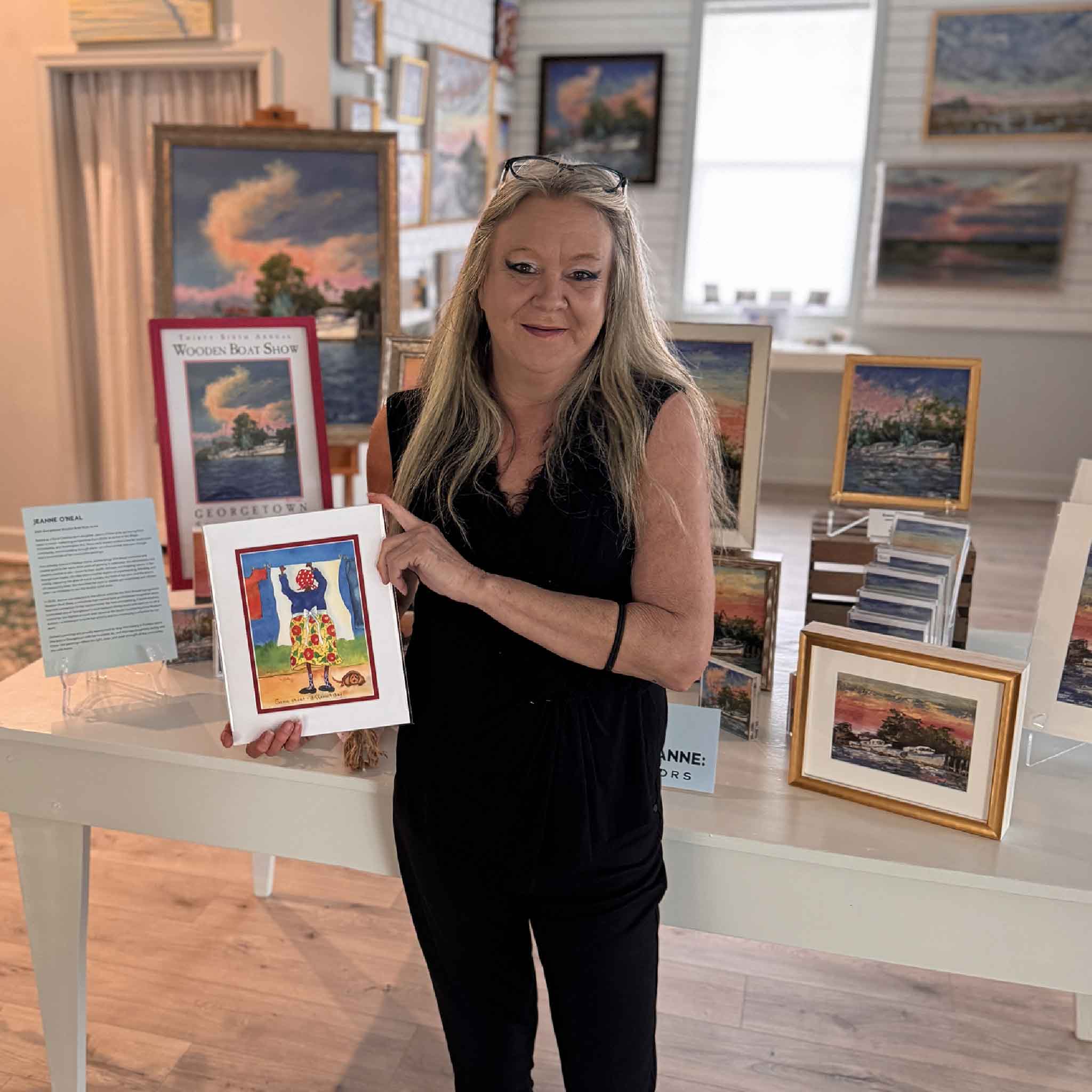 Matted 8x10 Vida Miller print titled “Same Sheet, Different Day,” featuring a colorful Little Lady hanging laundry with a dog resting at her feet. Pictured at Gray Man Gallery.