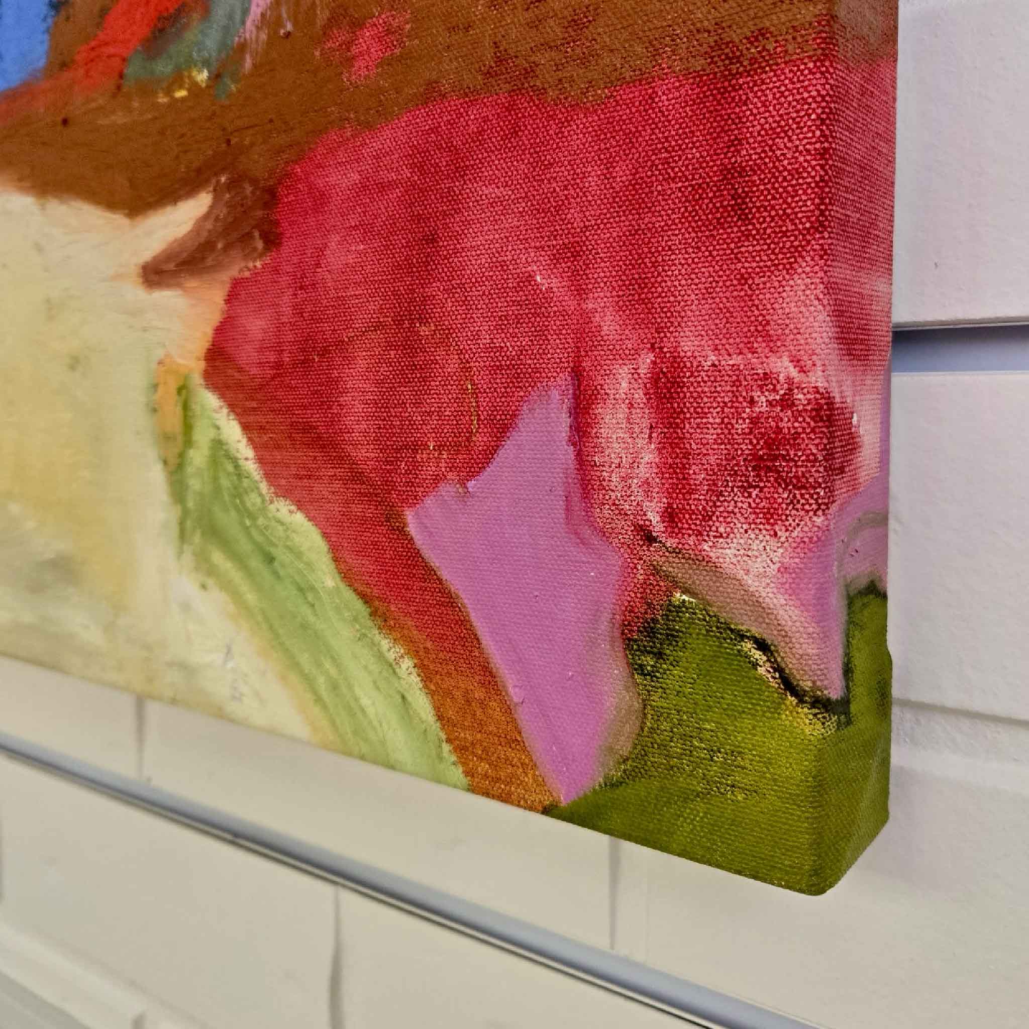 Close-up detail of “Abstract #10” by Caroline Young showing painted canvas edge, layered mixed media texture, coral pink, blush, green, and ochre brushwork, photographed at Gray Man Gallery in Pawleys Island
