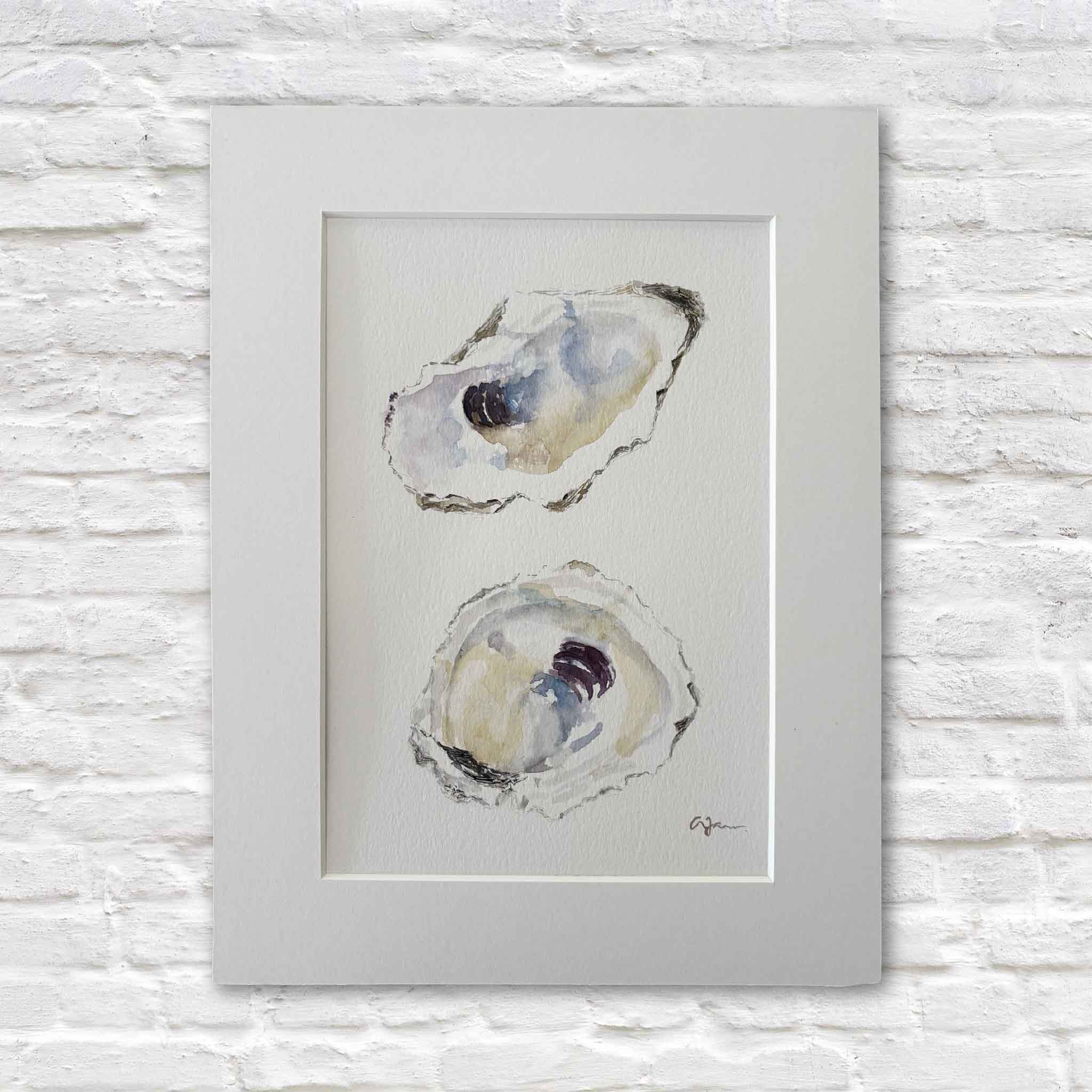 Original watercolor titled "Serendipity" by Lowcountry artist Allison Farr featuring two oyster shells painted in soft pearl whites, coastal blues, muted grays, and rich violet accents. Professionally matted to fit a standard 9x12 frame and available at Gray Man Gallery in Pawleys Island, South Carolina.