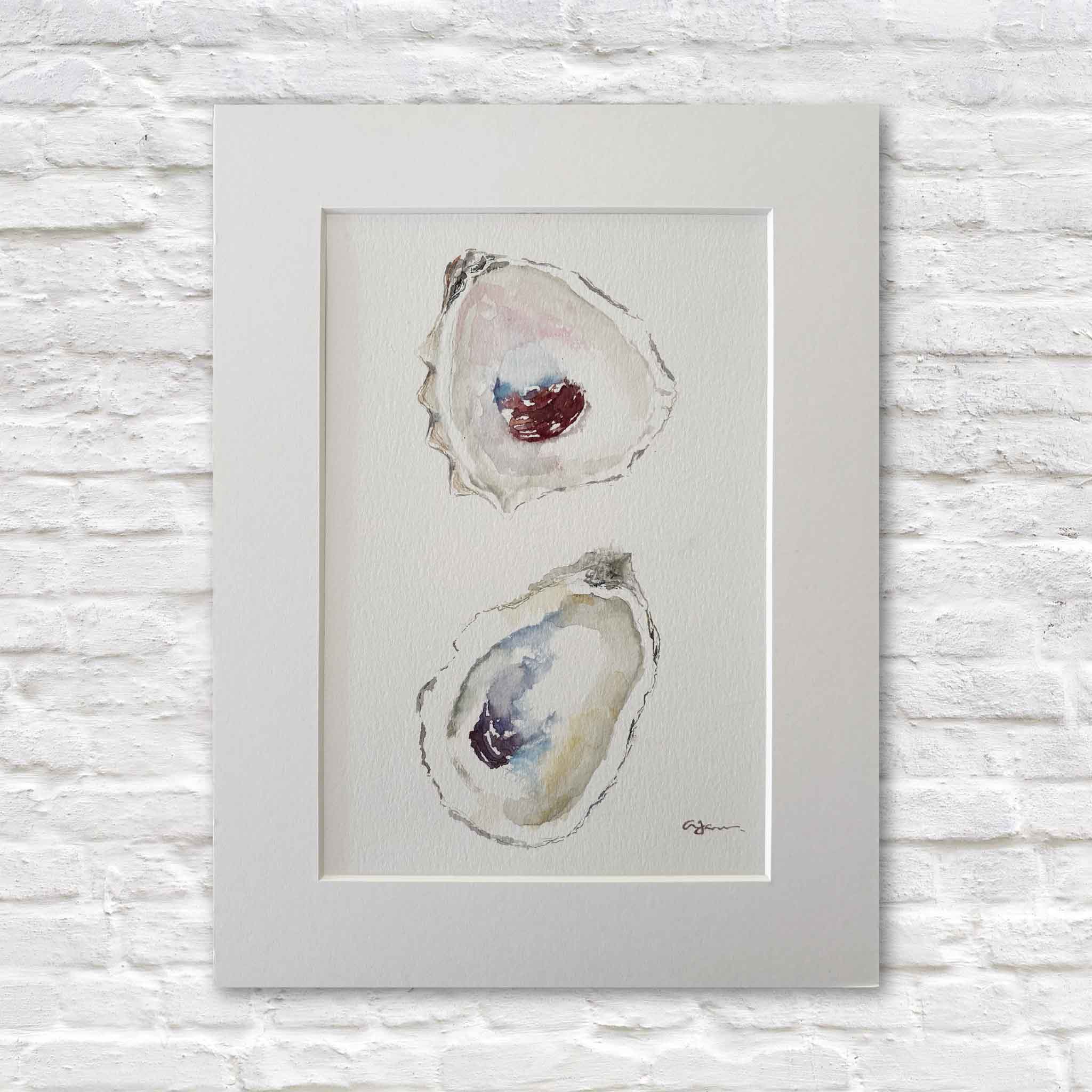 Original watercolor titled "Stillness" by Lowcountry artist Allison Farr featuring two delicately painted oyster shells with soft coastal blues, pearl whites, sandy neutrals, and jewel-toned centers. Professionally matted to fit a standard 9x12 frame and available at Gray Man Gallery in Pawleys Island, South Carolina.