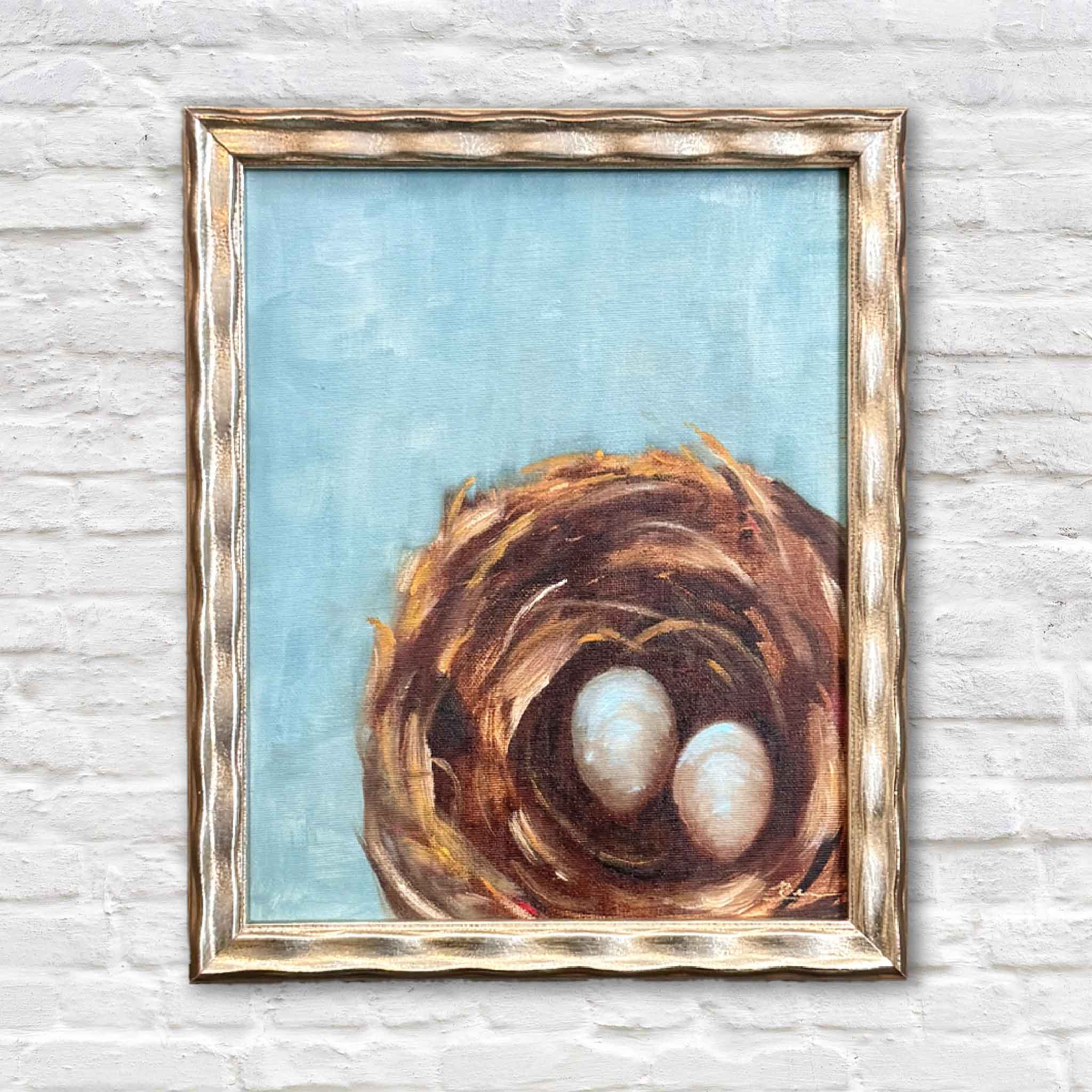 Original oil painting by Jenny Reynolds featuring a textured bird’s nest with two eggs, framed in soft gold against a sky-blue background.