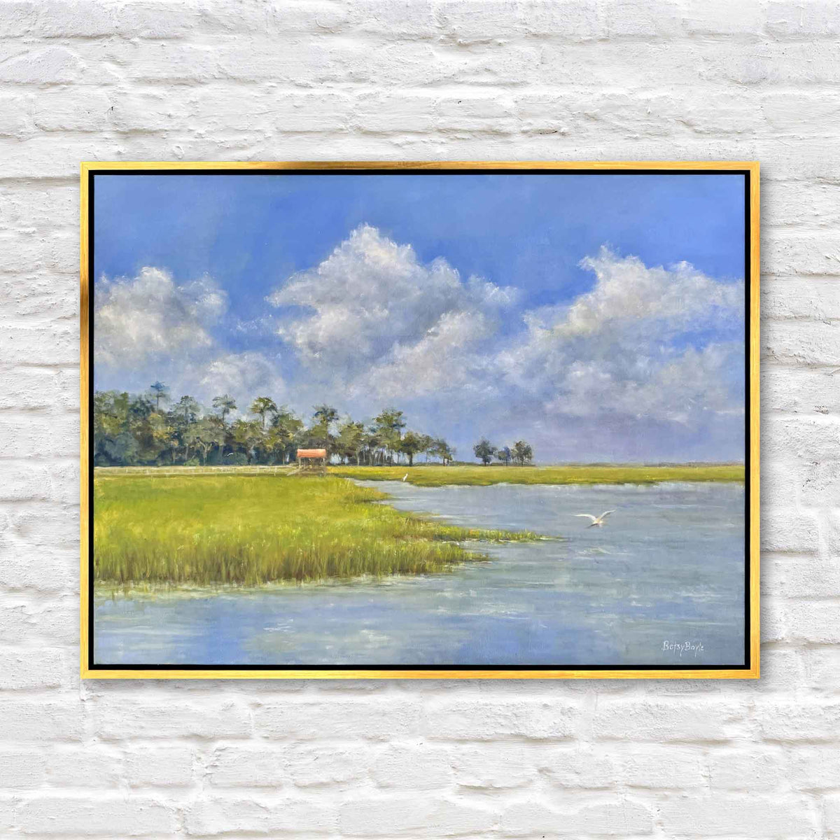 Blue and Green of Summer II original oil painting by local South Carolina artist Betsy Boyle featuring a brilliant blue summer sky, towering white clouds, green Lowcountry marsh grass, winding tidal creek and flying egret, framed in gold and available at Gray Man Gallery in Pawleys Island