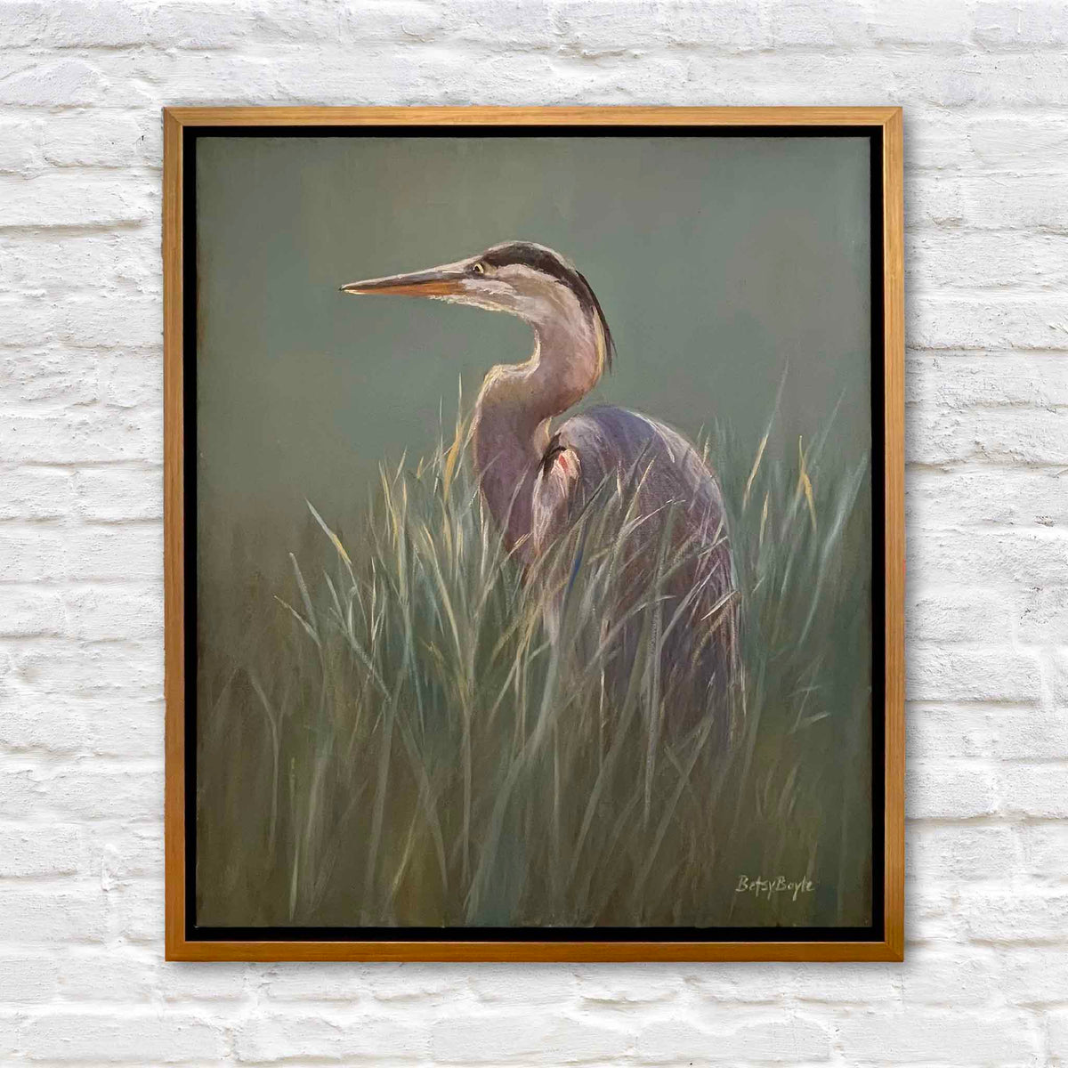 Cool Light original oil painting by South Carolina artist Betsy Boyle featuring a great blue heron standing among tall Lowcountry marsh grasses in muted sage green, blue-gray and soft lavender tones, framed and available at Gray Man Gallery in Pawleys Island, South Carolina