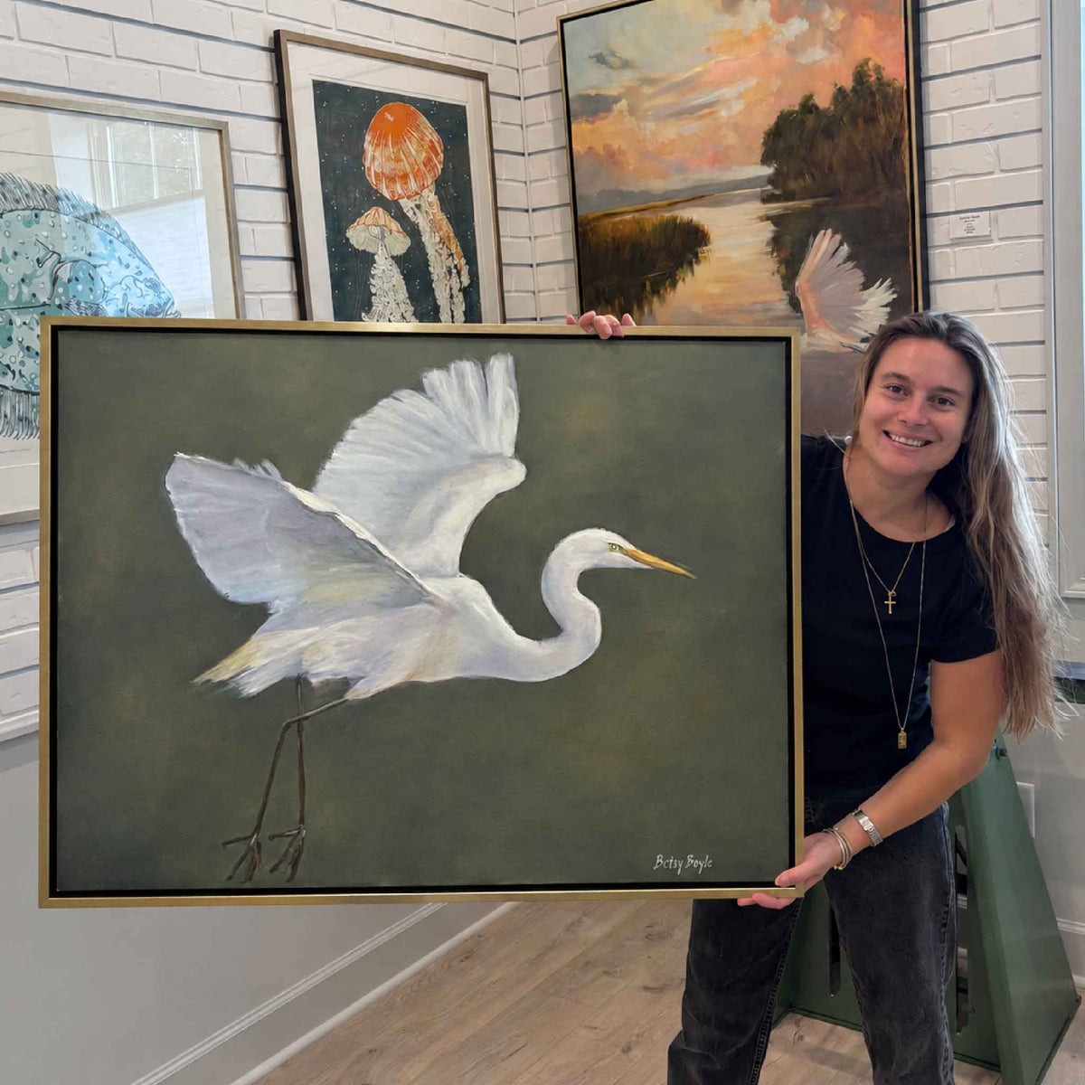 Large framed original oil painting Purpose by local artist Betsy Boyle featuring a white great egret with outstretched wings, shown on display at Gray Man Gallery in Pawleys Island, South Carolina