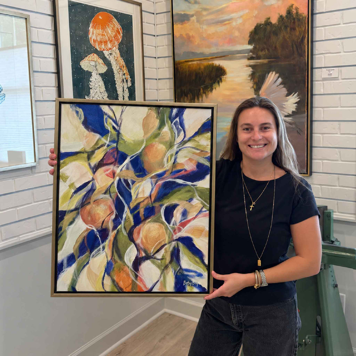 Richly Fruitful original oil painting by local artist Betsy Boyle shown inside Gray Man Gallery in Pawleys Island, South Carolina, featuring colorful abstract fruit and foliage in blue, green, cream, peach and warm orange tones