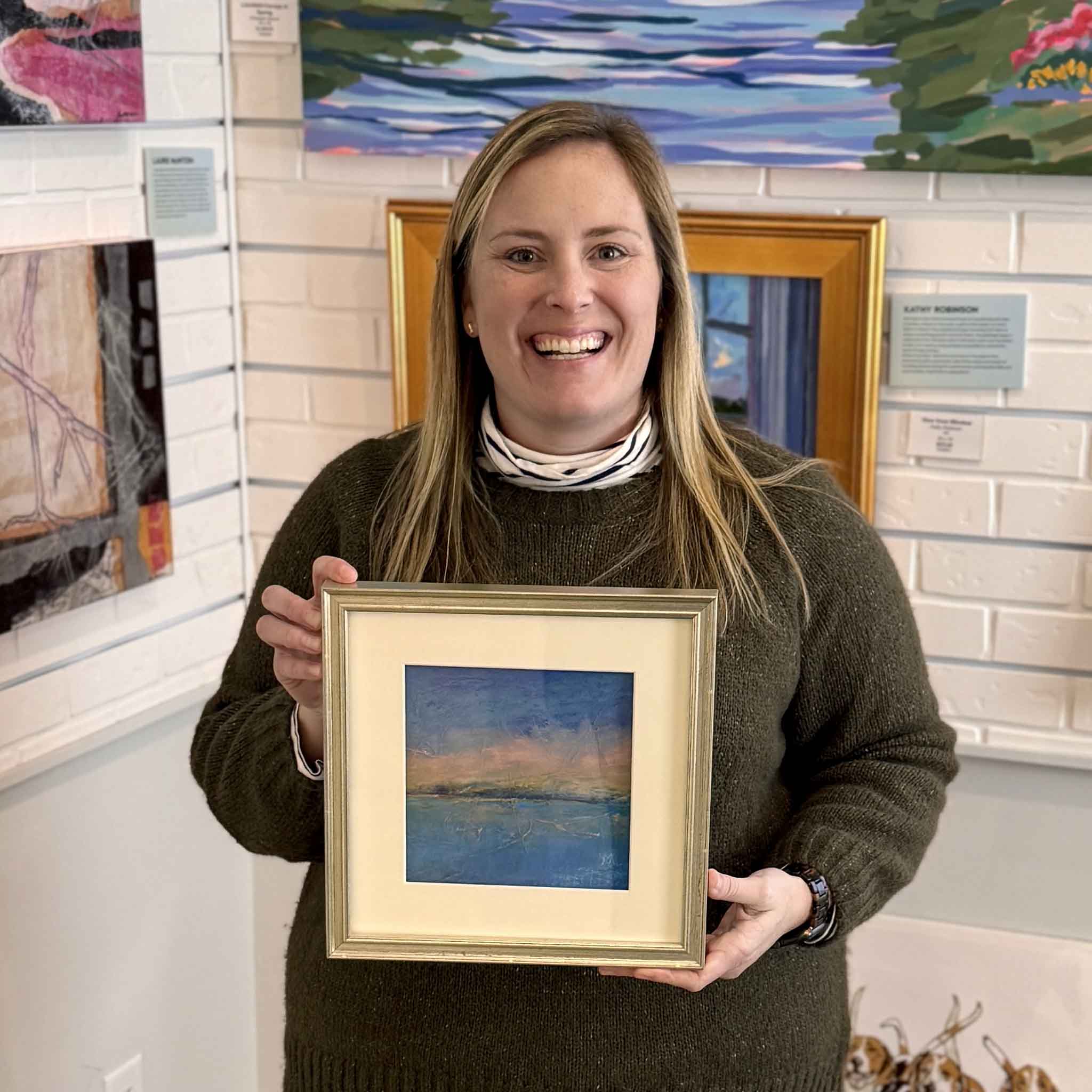 Bordy holding Serenity, an original pastel coastal landscape by Pawleys Island artist Vida Miller at Gray Man Gallery in Pawleys Island South Carolina
