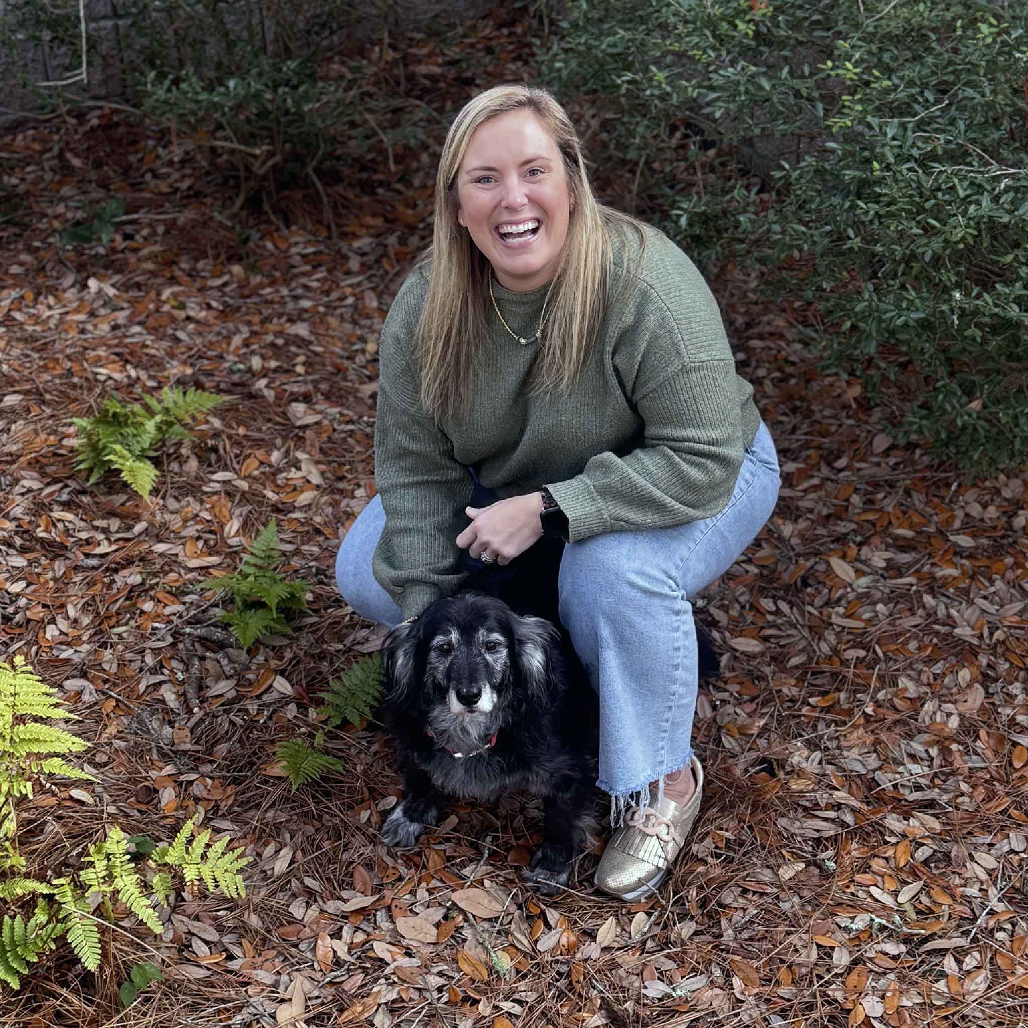Bordy, a team member at Gray Man Gallery, pictured with rescue dog Buddy in the gallery courtyard in Pawleys Island, South Carolina.